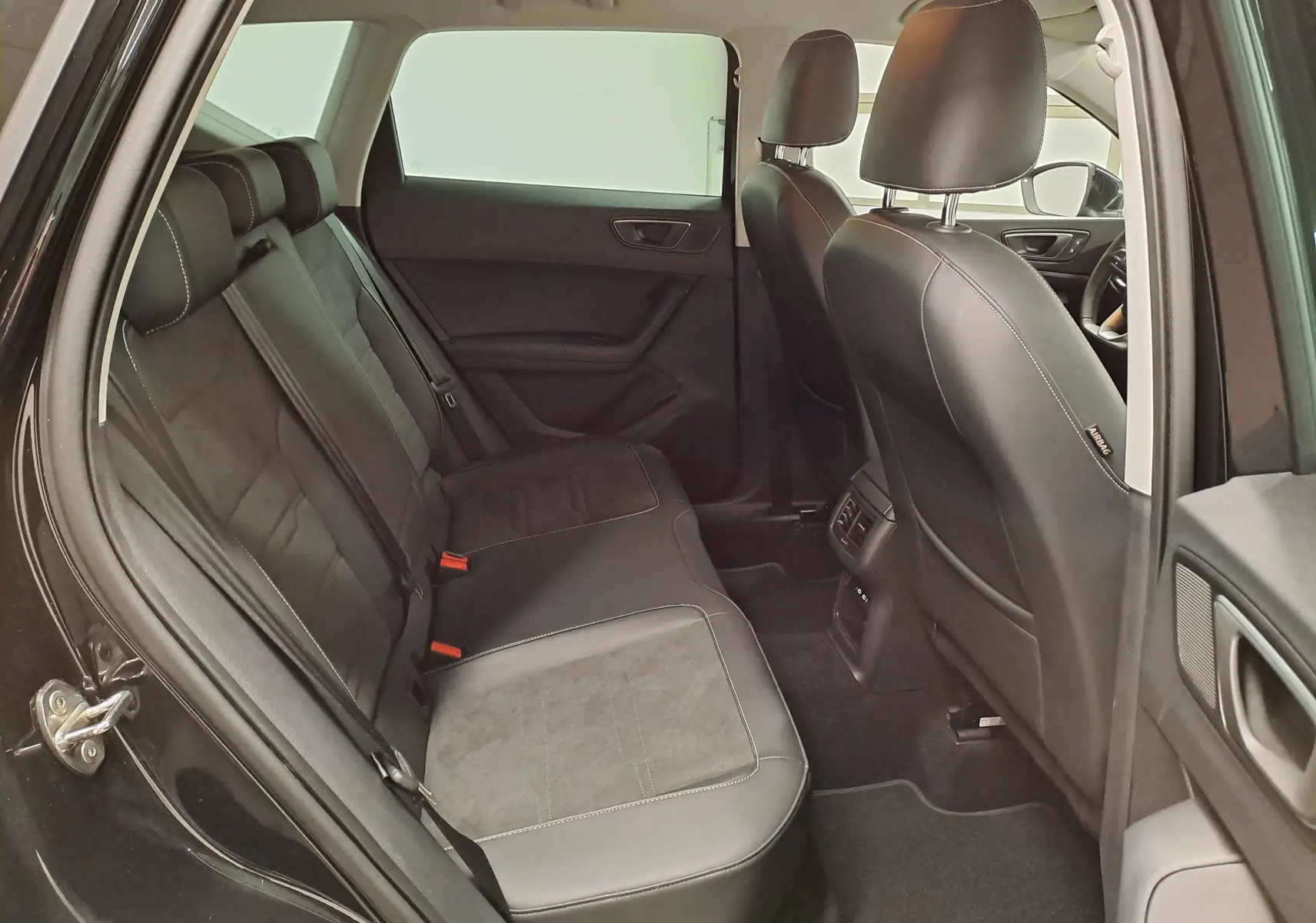Vue intérieure côté gauche sur les sièges arrière en suédine noire avec surpiqûres grises du SEAT Ateca Noir Minuit 2023.