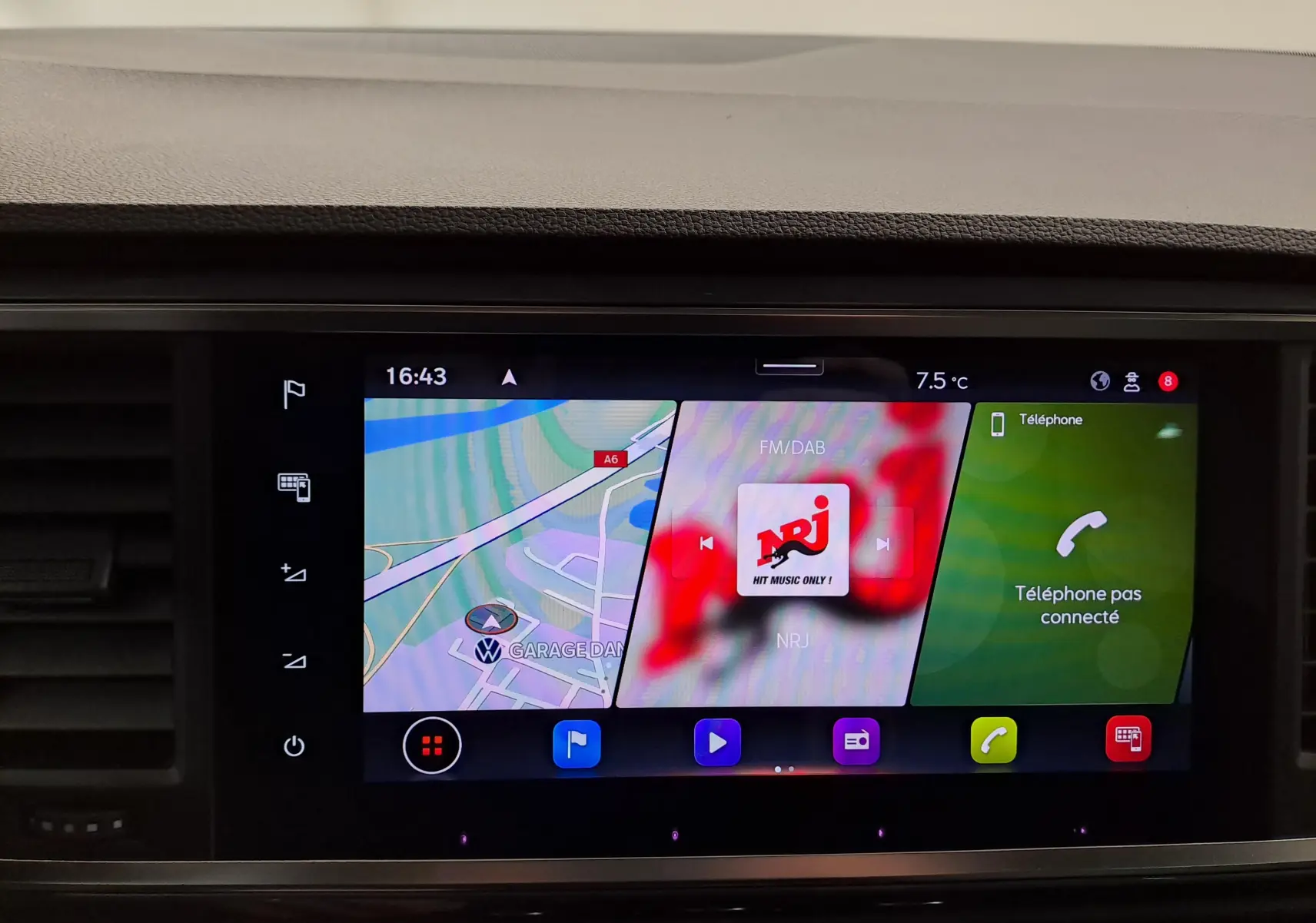 Vue avant rapprochée du tableau de bord noir Titane du SEAT Ateca 2023, écran tactile affichant navigation et radio NRJ.