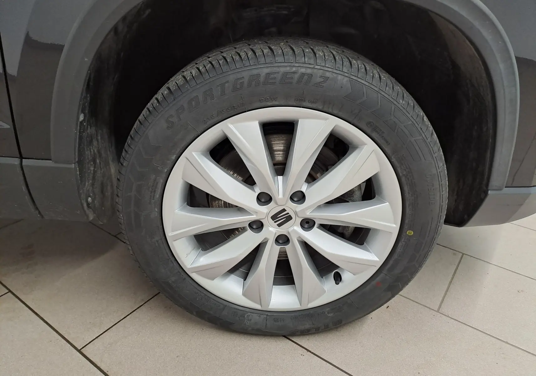 Gros plan sur la roue avant droite d’un SEAT Ateca Noir Minuit, mettant en valeur la jante argentée à 10 branches.