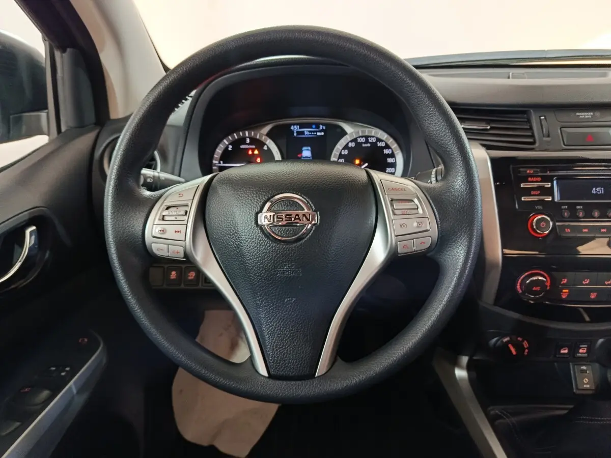 Vue centrée sur le volant multifonctions noir du Nissan Navara 2018 avec tableau de bord et console centrale visibles.
