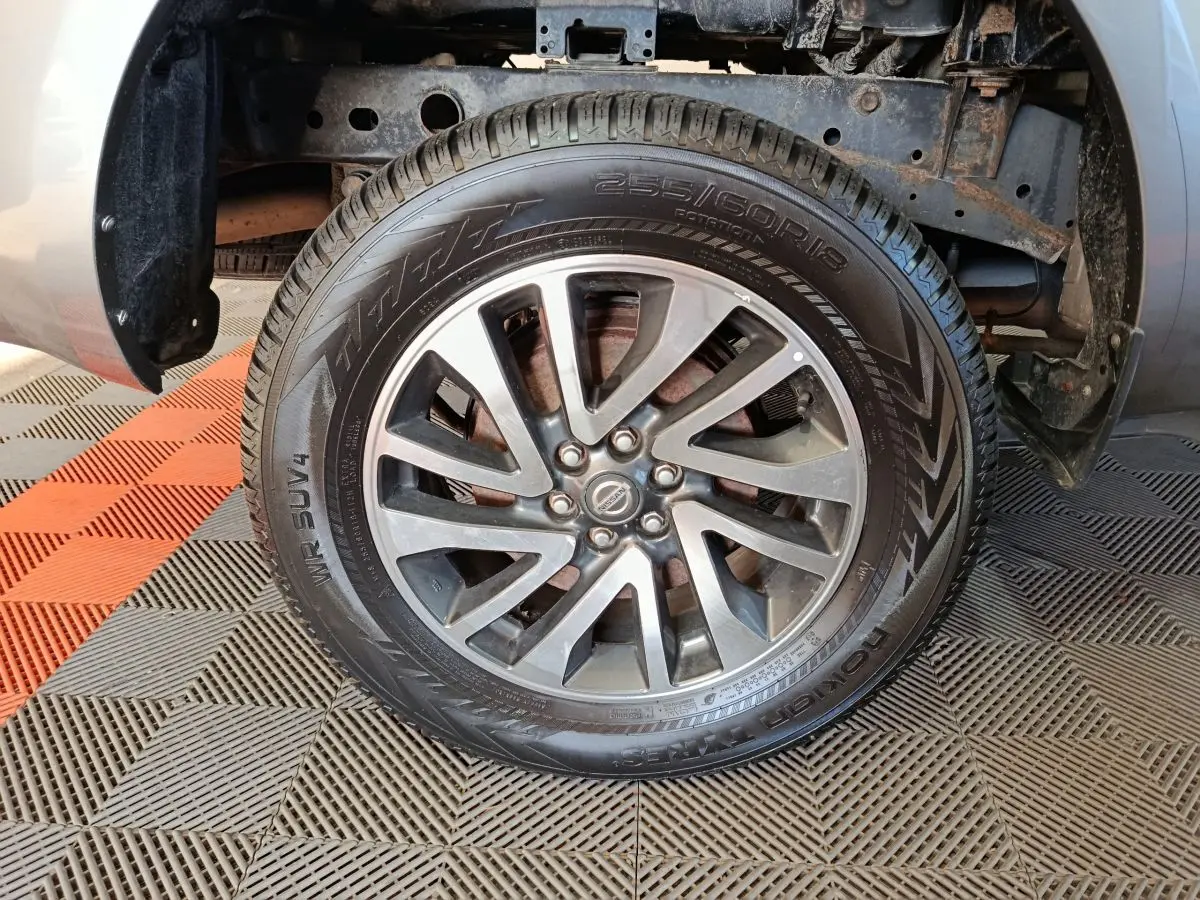 Gros plan sur la roue avant droite gris clair du Nissan Navara 2018, jante alliage et pneu tout-terrain visibles.