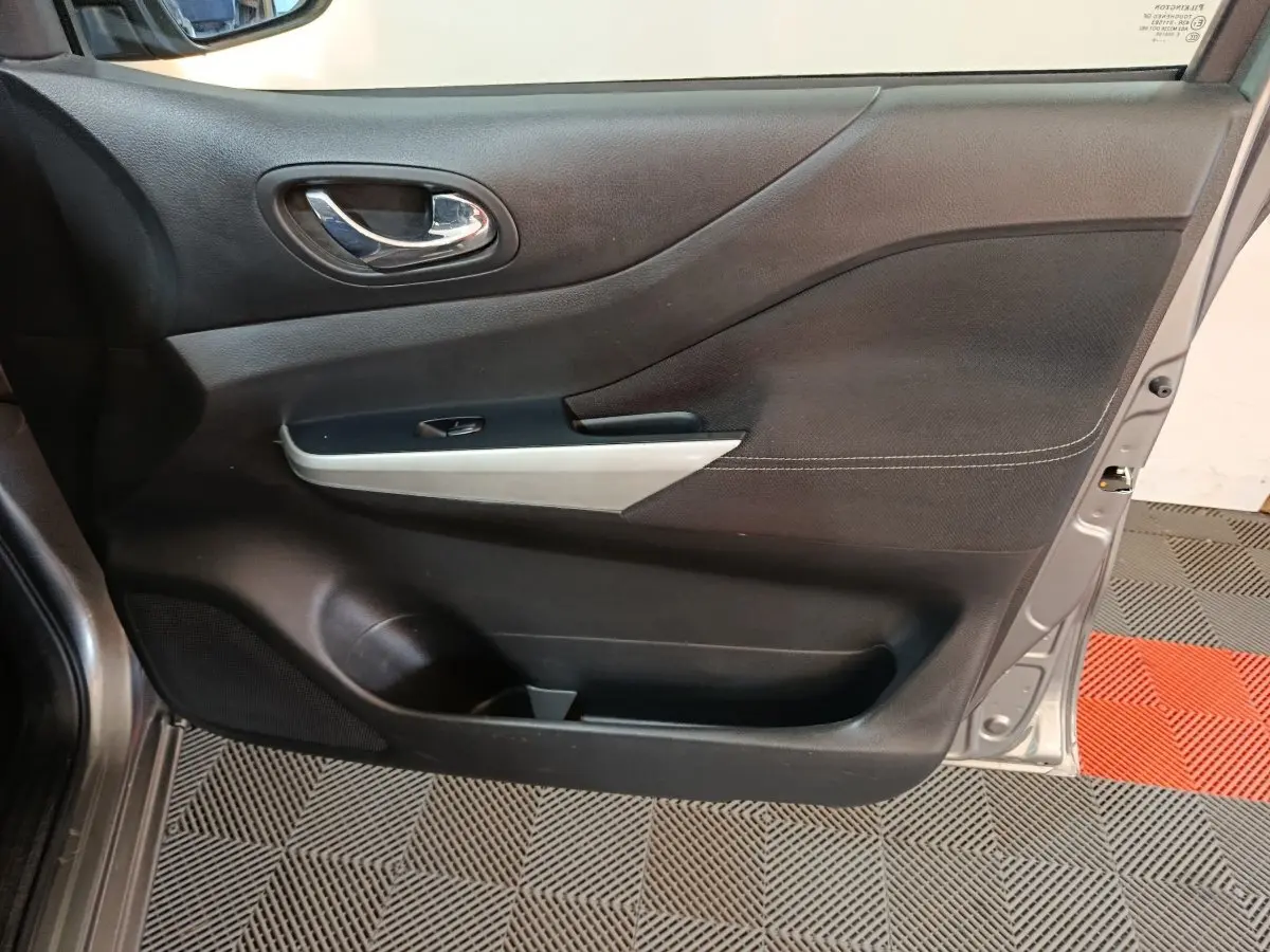 Vue rapprochée de la porte avant droite gris clair du Nissan Navara 2018 avec poignée chromée et garniture noire.