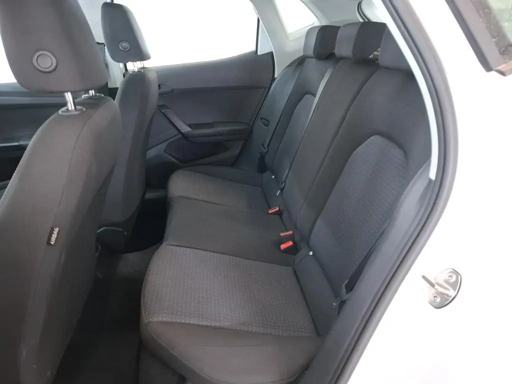 Vue rapprochée des commandes de lève-vitres et réglage des rétroviseurs sur la porte côté gauche d'une SEAT Ibiza blanche.