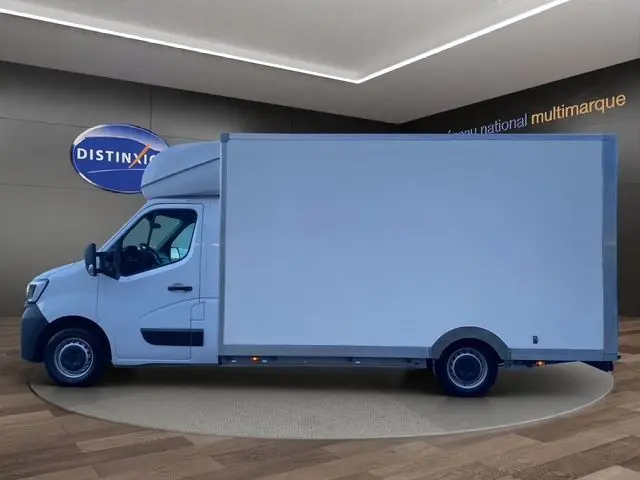 Vue latérale gauche d’un Renault Master blanc 2022 avec caisse de grande capacité, présenté en intérieur showroom.