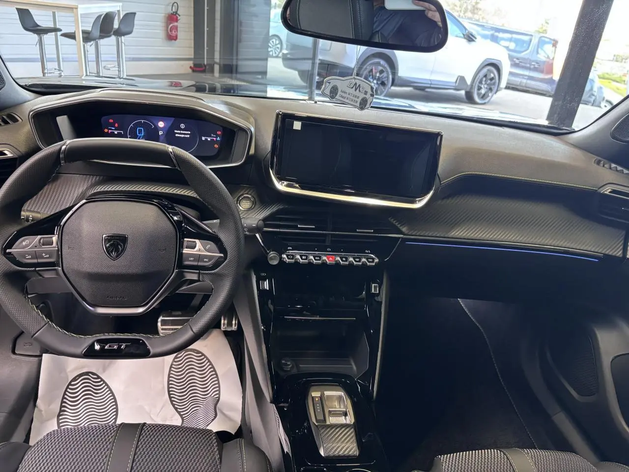 Vue intérieure avant du Peugeot 2008 GT hybride noire, avec tableau de bord numérique et écran tactile central.
