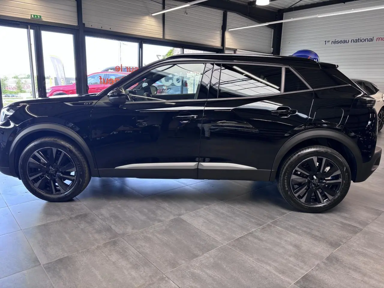 Peugeot 2008 noire vue de profil côté gauche, avec jantes alliage noires et toit Black Diamond.