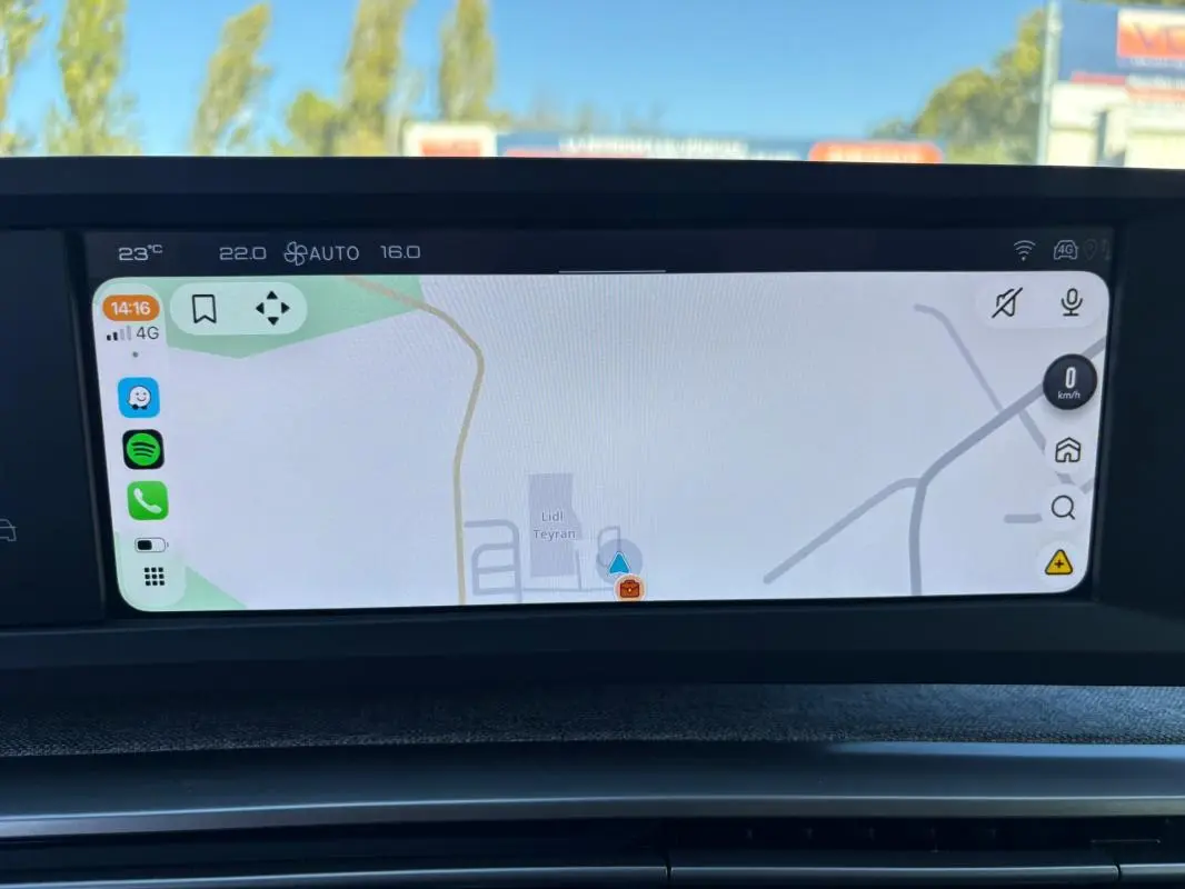 Écran tactile central affichant la navigation dans un Peugeot 5008 bleu foncé, vue intérieure frontale.
