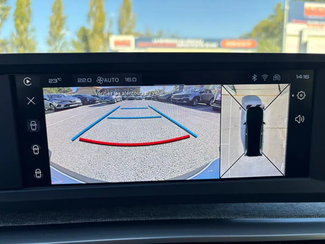 Affichage de la caméra de recul et vue 360° du Peugeot 5008 bleu foncé Hybrid 145 ch, avec repères de stationnement visibles.