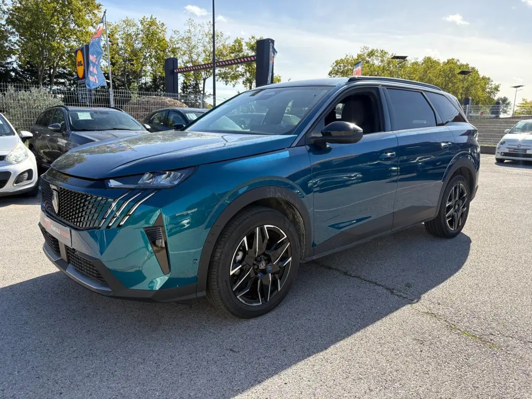 Peugeot 5008 Hybrid bleu foncé en 3/4 avant droit, avec calandre distinctive et jantes noires stylées.