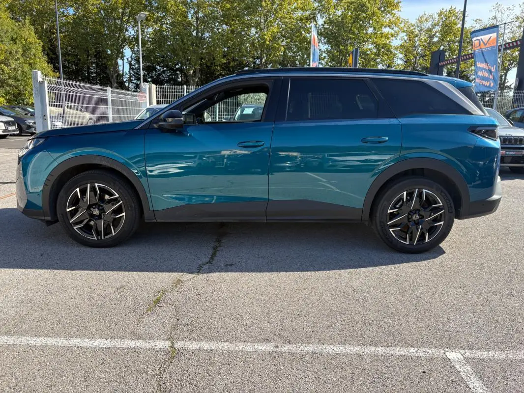 Vue de profil côté gauche d’un Peugeot 5008 Hybrid 145 ch e-DCS6 Allure bleu foncé avec jantes noires et toit noir.