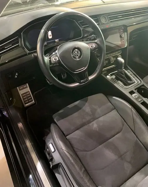 Intérieur noir du Volkswagen Arteon 2019, vue côté conducteur sur le volant, siège et console centrale avec boîte auto.