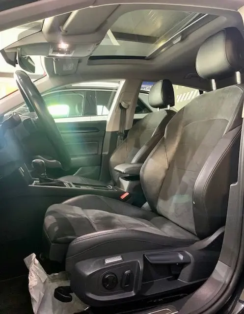 Intérieur du Volkswagen Arteon 2019, sièges avant en cuir et alcantara, toit ouvrant panoramique visible côté conducteur.