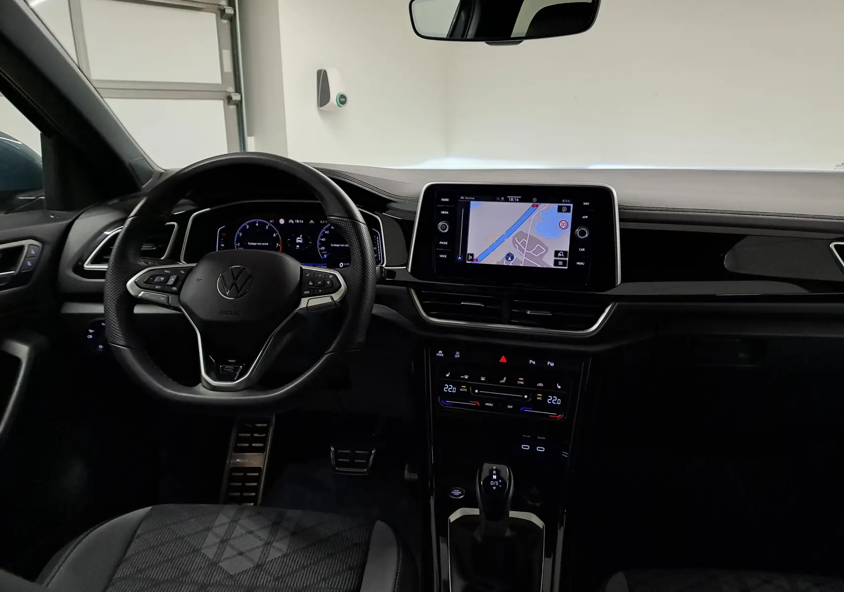 Vue intérieure du tableau de bord du Volkswagen T-Roc 1.5 TSI 150 DSG7 R-Line Edition avec écran tactile et volant multifonction.