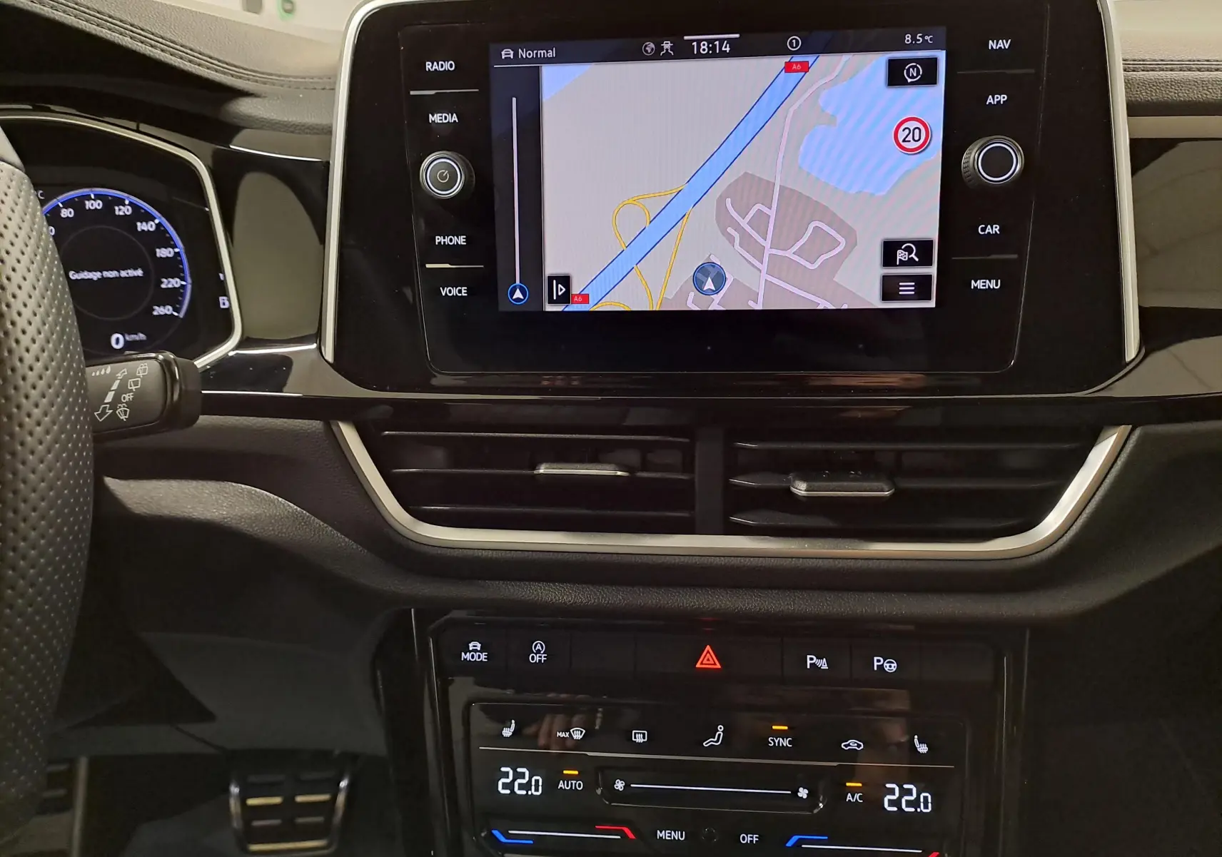 Vue rapprochée de l’écran tactile central et du tableau de bord du Volkswagen T-Roc 1.5 TSI Bleu Pétrole avec commandes climatisation digitales.