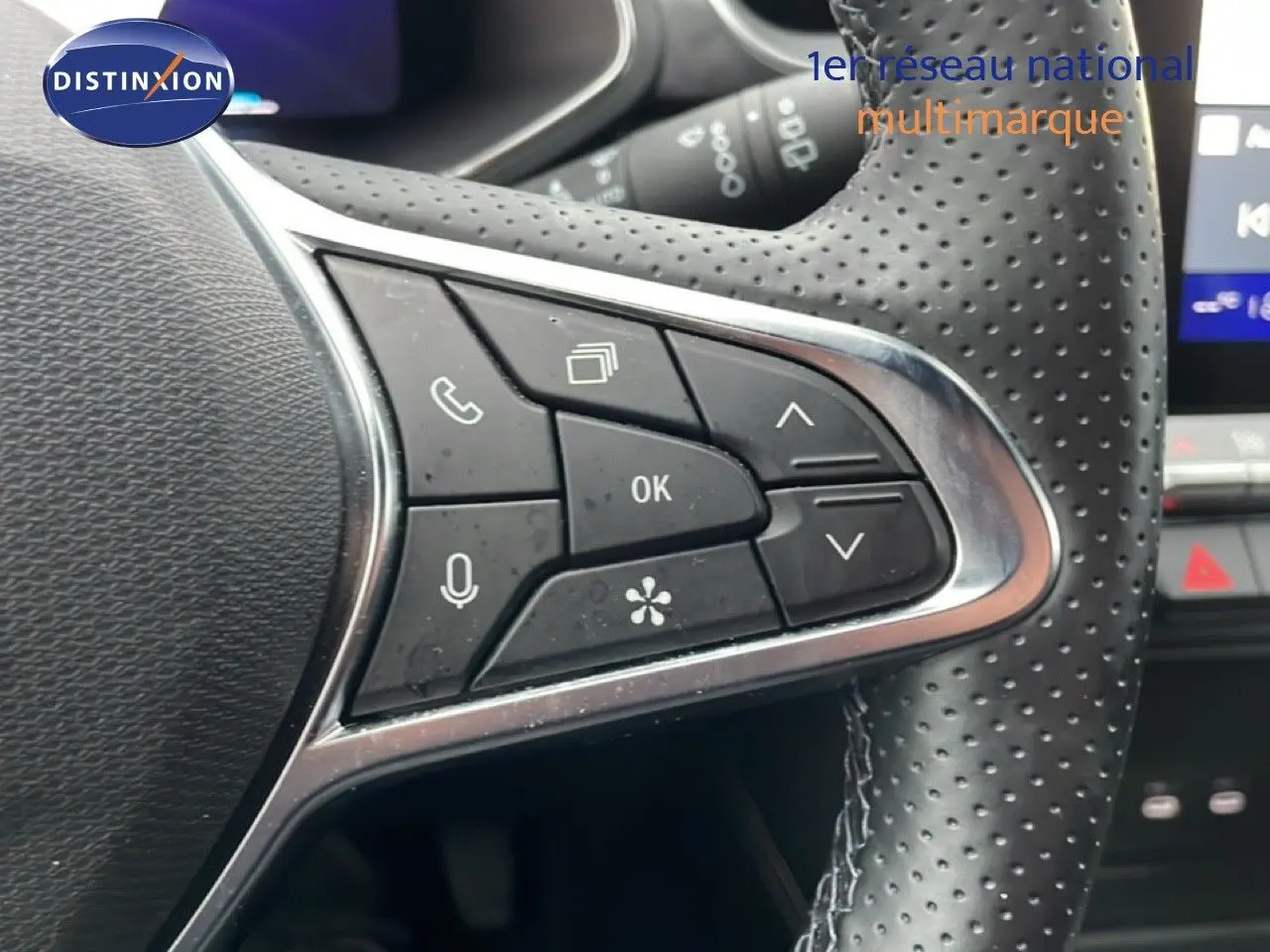 Gros plan sur les commandes multifonctions en cuir perforé du volant du Renault Symbioz noir étoile métal, version hybride 2025.