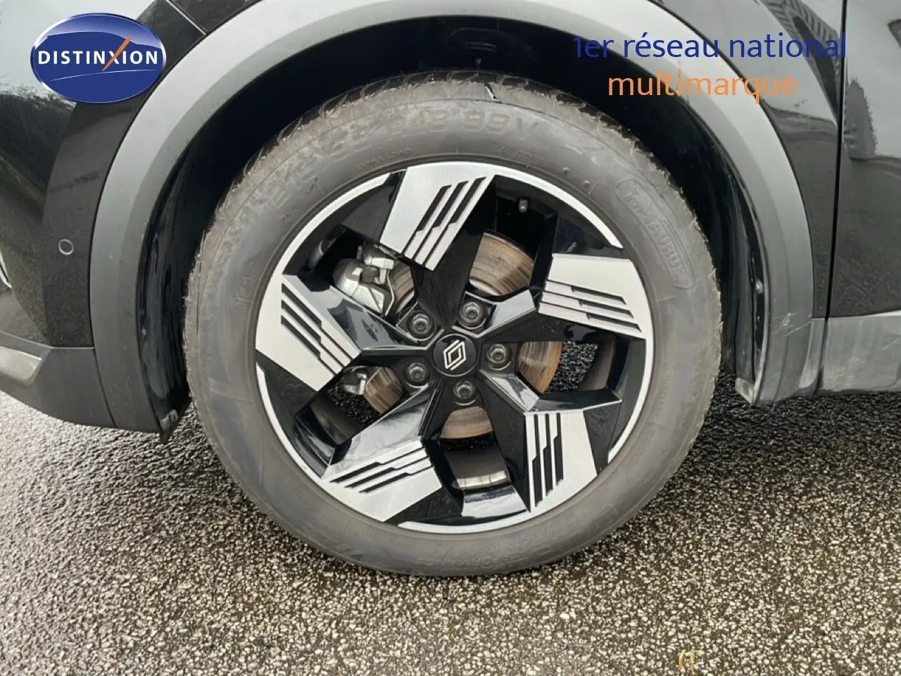 Gros plan sur la roue avant droite du Renault Symbioz noir étoile métal, mettant en valeur la jante au design moderne bicolore.