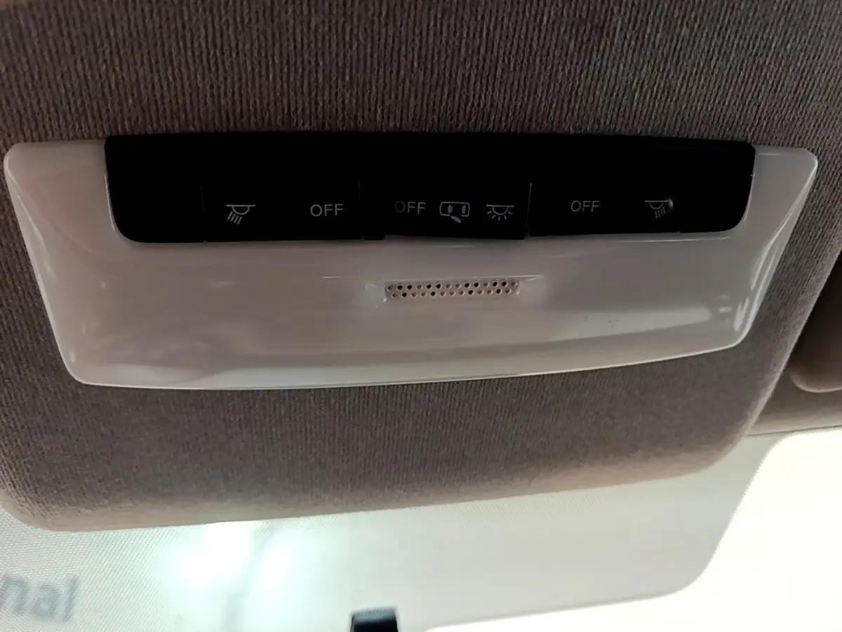 Plafonnier intérieur avec boutons de commande d’éclairage dans une Nissan Micra gris foncé, vue de dessous.