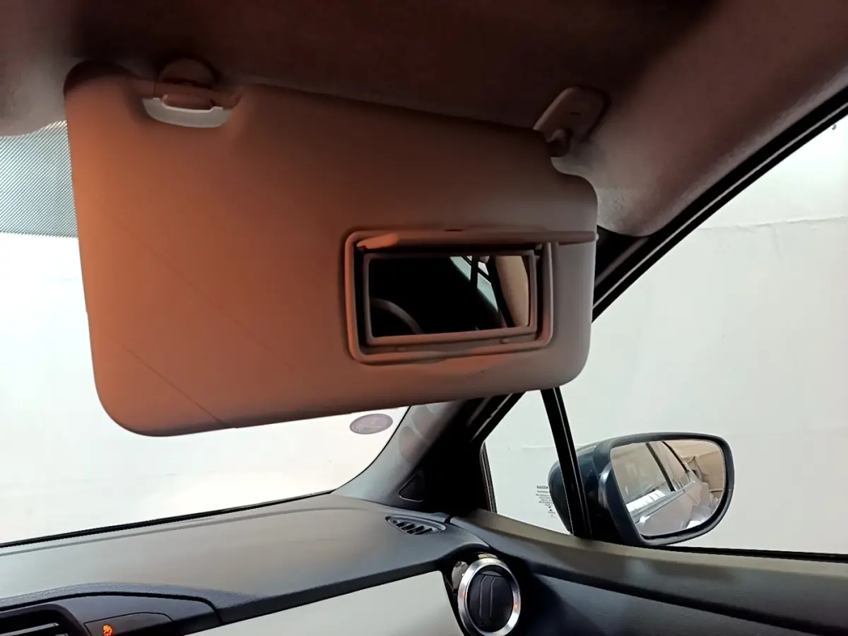 Intérieur de la Nissan Micra Business Edition 2020, vue côté passager avec pare-soleil rabattable et rétroviseur extérieur visible.