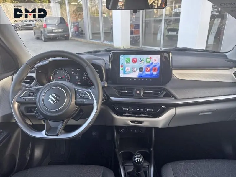 Vue intérieure avant de la Suzuki Swift 1.2 Hybrid avec volant cuir multifonction et écran tactile central lumineux.