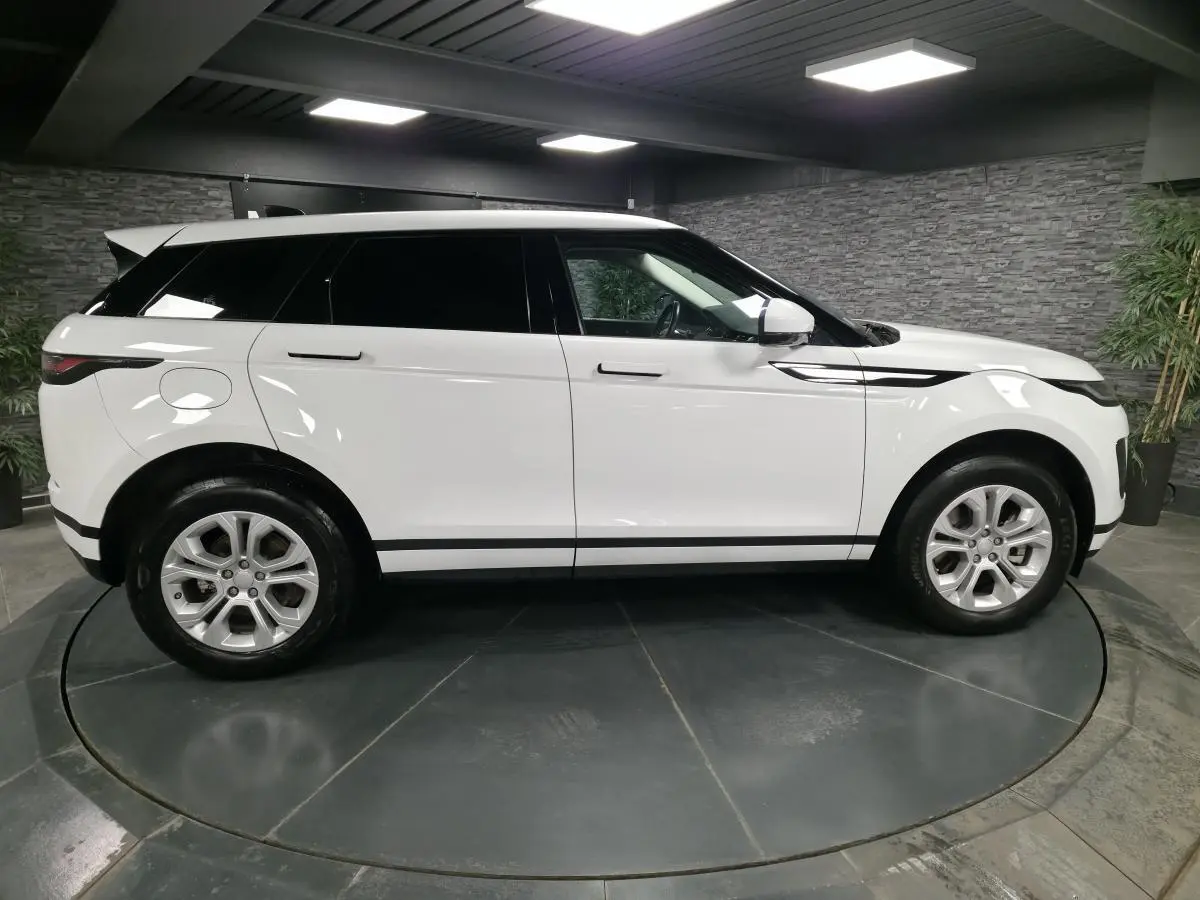 Vue de profil côté gauche d'un Range Rover Evoque blanc 2020 avec jantes 18 pouces et toit assorti.