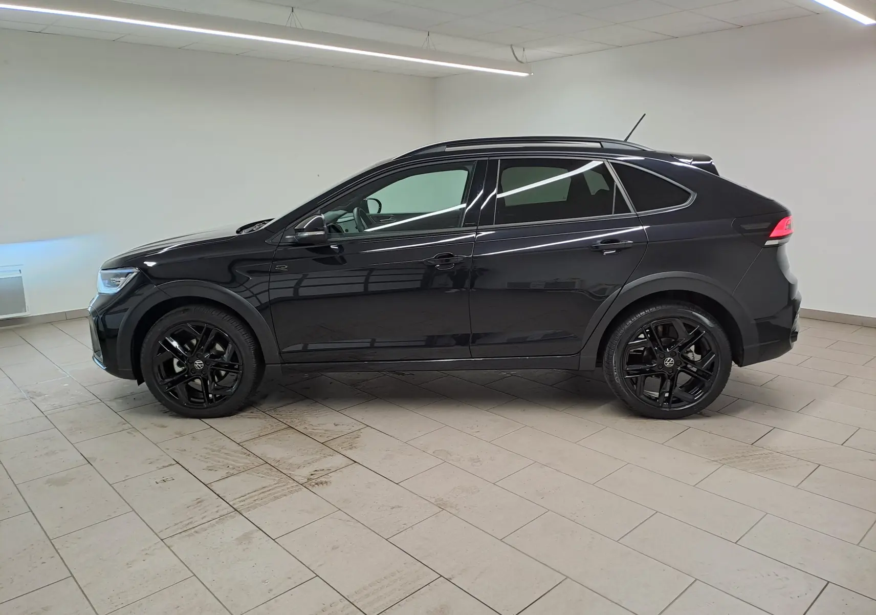 Profil côté gauche d'un Volkswagen Taigo 1.5 TSI R-Line noir intense nacré avec jantes noires 18 pouces York.