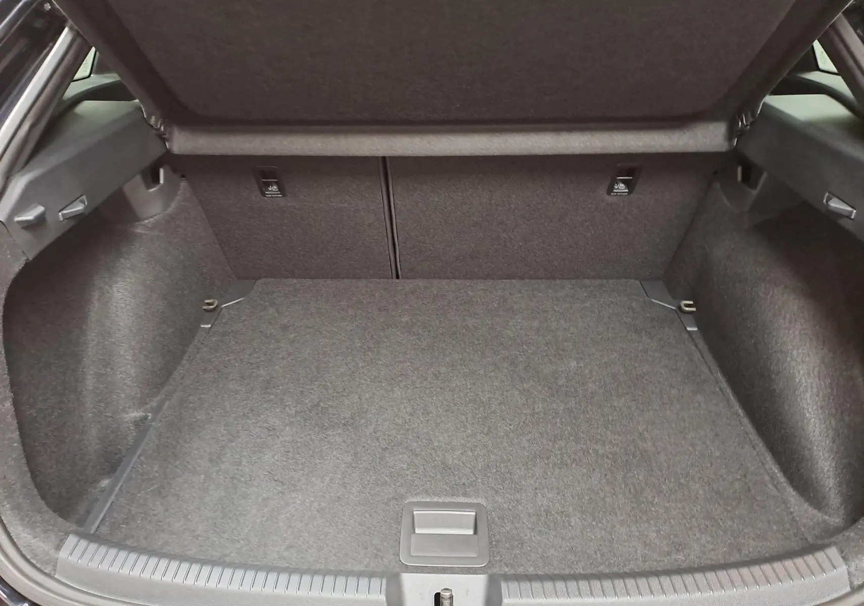 Coffre ouvert de Volkswagen Taigo 1.5 TSI 150 DSG7 R-Line Edition noir intense nacré, vue intérieure arrière.