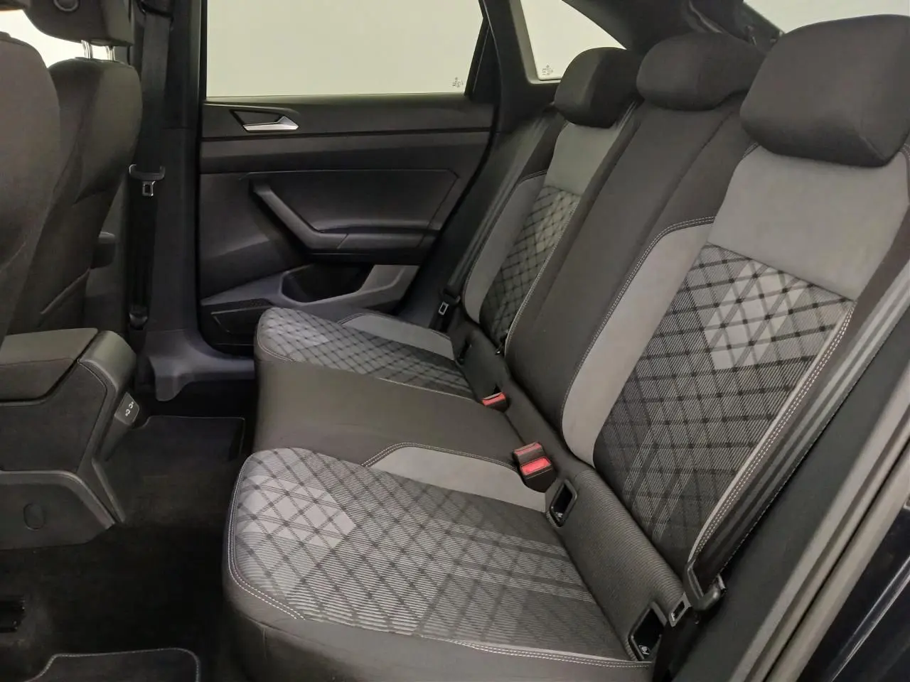 Vue latérale intérieure des sièges arrière du Volkswagen Taigo 2025, tissu noir et gris à motifs géométriques.