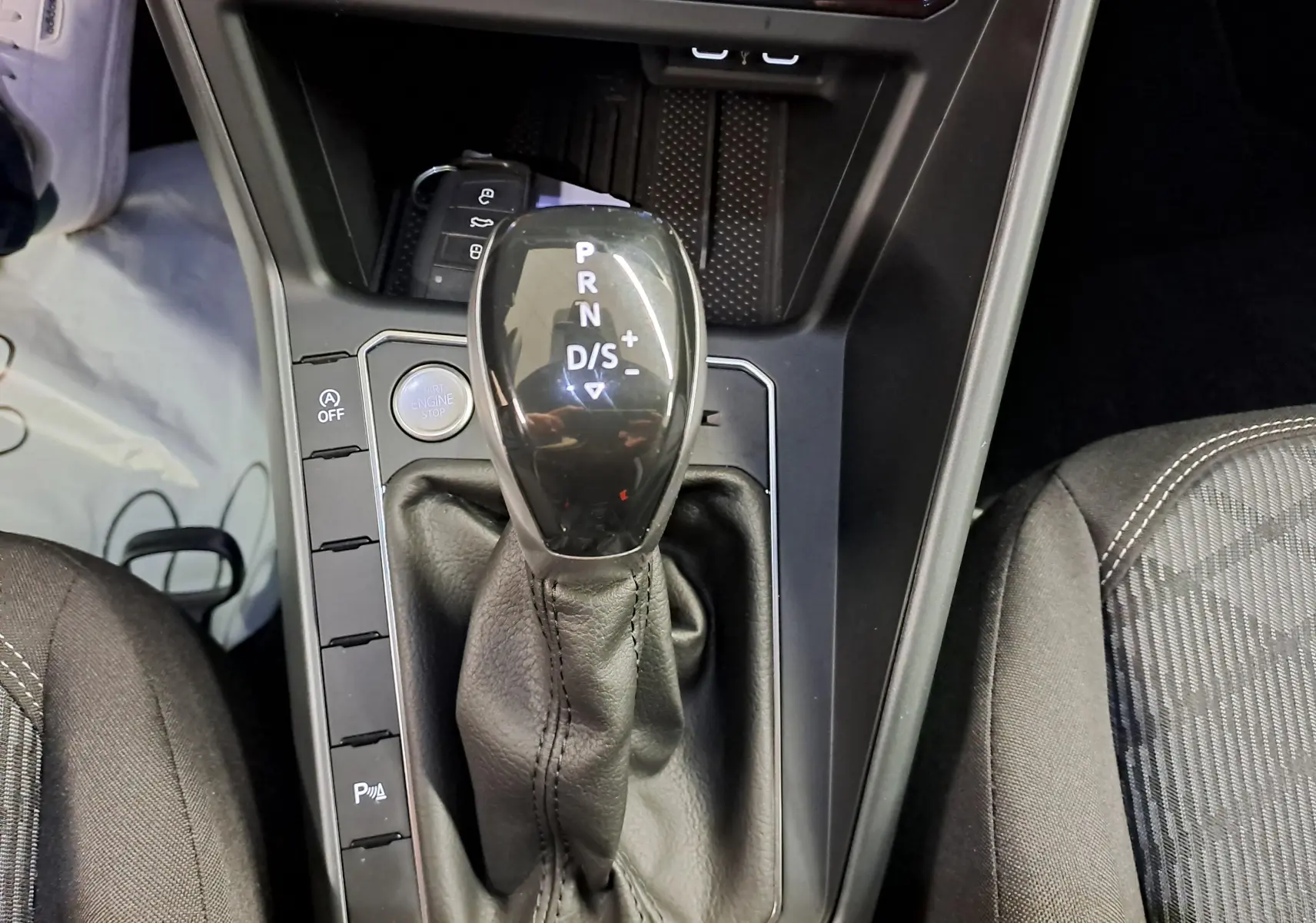 Gros plan sur le levier de vitesses automatique noir et cuir du Volkswagen Taigo 1.5 TSI R-Line Edition, intérieur sombre.