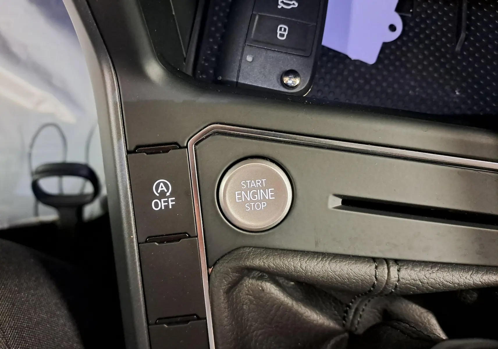 Gros plan sur la console centrale noire avec bouton Start Engine Stop et commande auto start/stop du Volkswagen Taigo 2025.