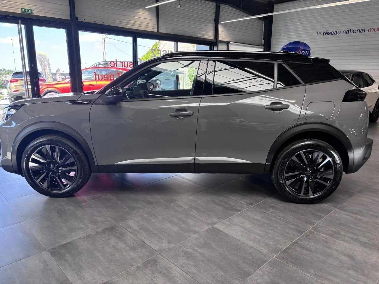 Peugeot 2008 gris selenium vue de profil côté gauche, avec toit noir et jantes alliage bi-ton noir brillant.