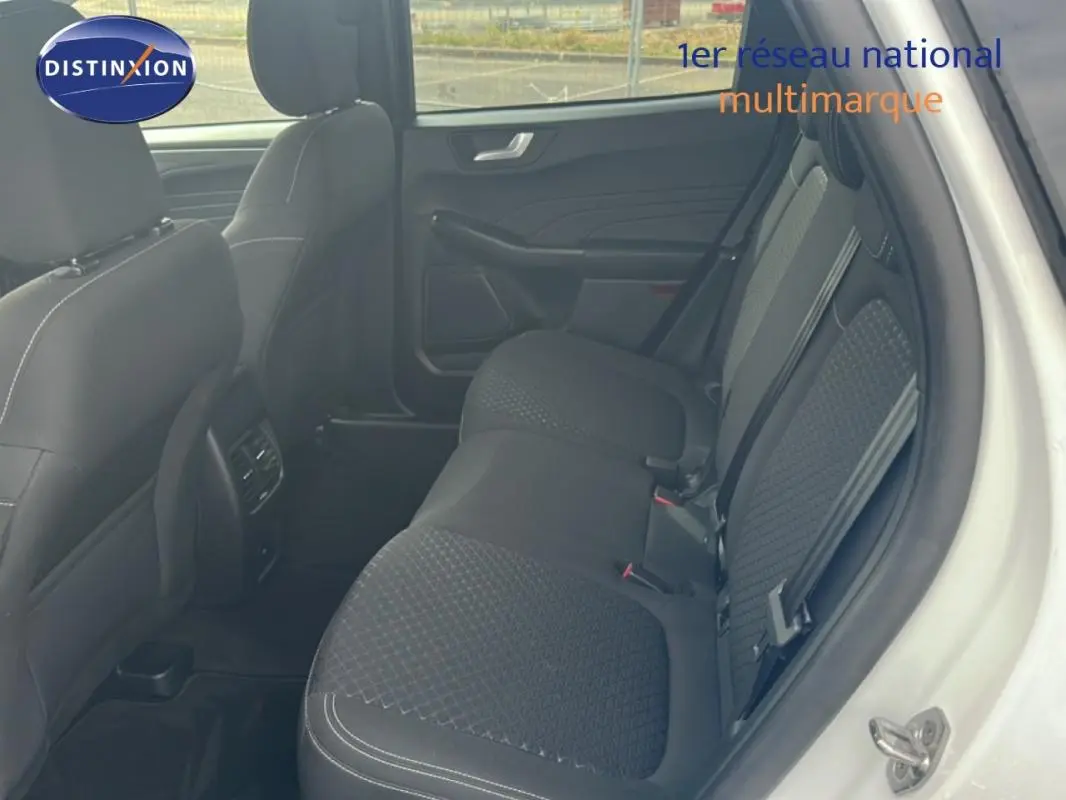 Vue intérieure côté droit montrant la banquette arrière noire avec surpiqûres du Ford Kuga blanc 2025.