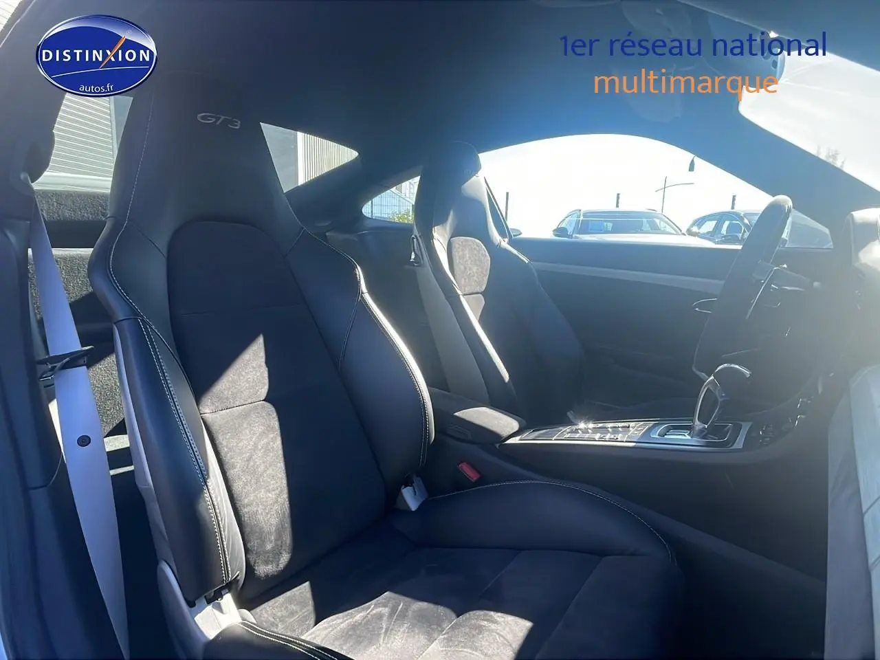 Intérieur vu côté droit de la Porsche 911 GT3 blanc, sièges sport cuir/alcantara noirs avec surpiqûres blanches.