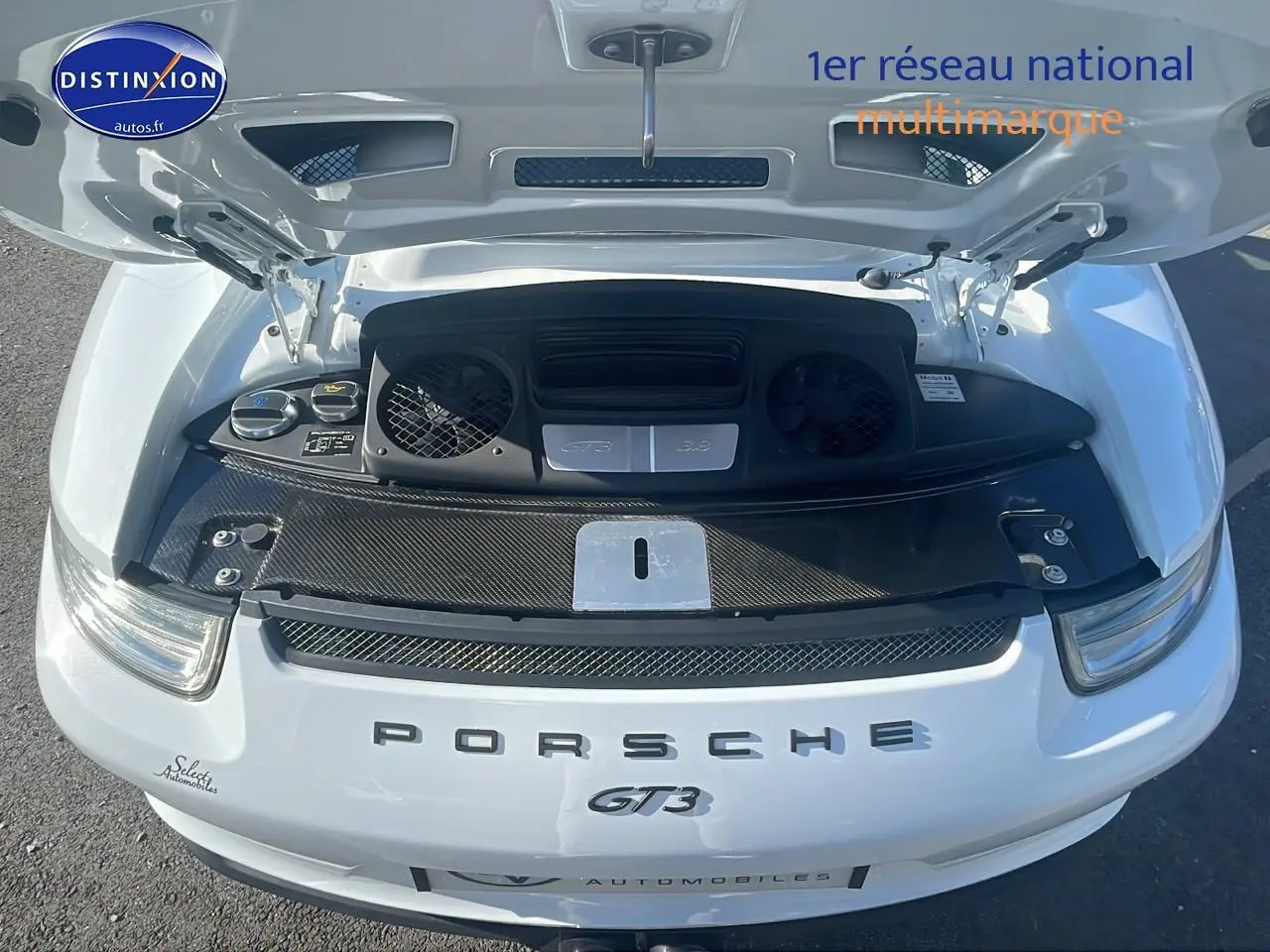 Vue de dessus du moteur ouvert d'une Porsche 911 (991) GT3 blanche, mettant en valeur le capot arrière et les grilles d'aération.
