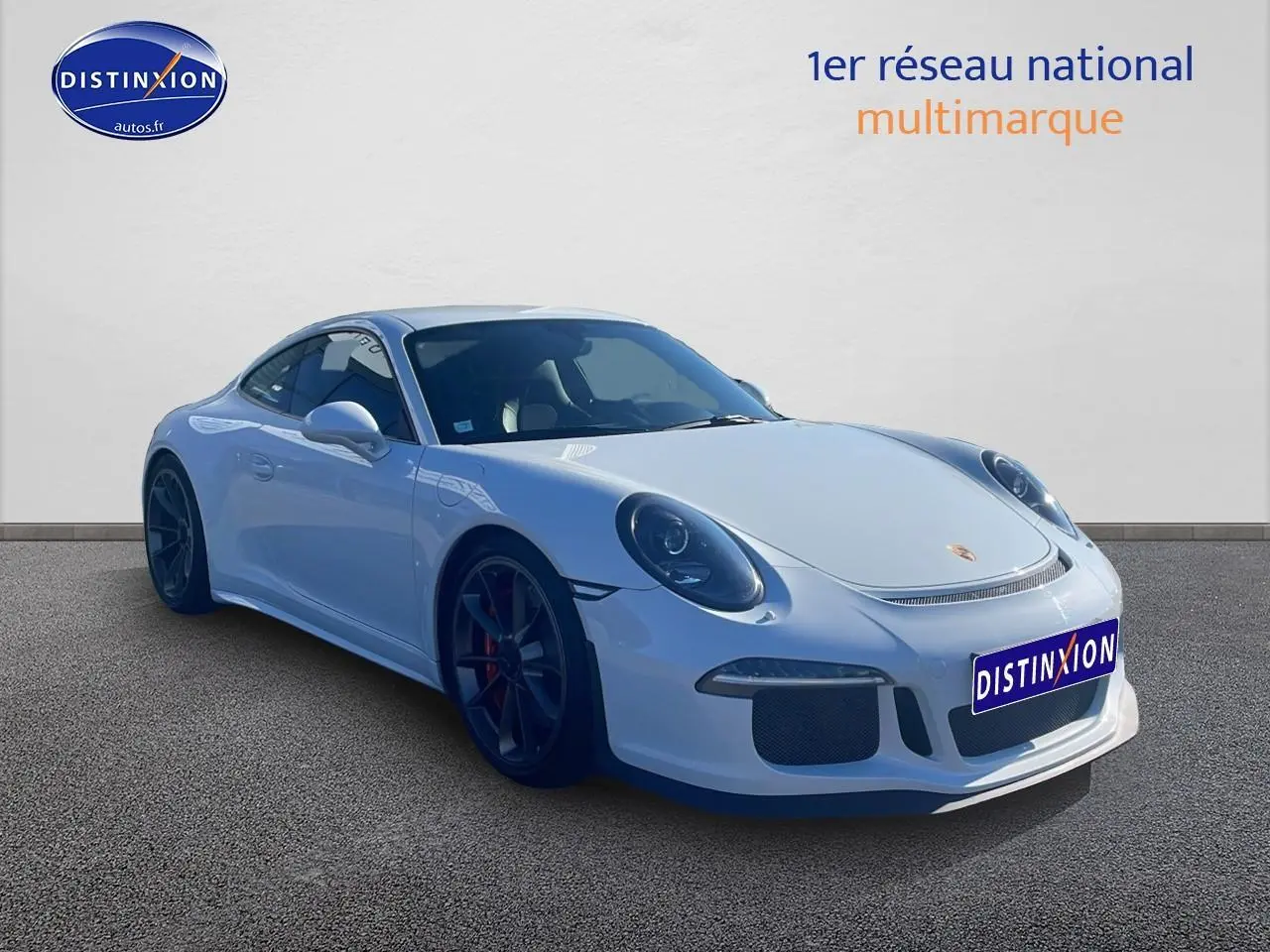 Vue 3/4 avant d'une Porsche 911 GT3 blanche avec jantes noires et becquet arrière visible.