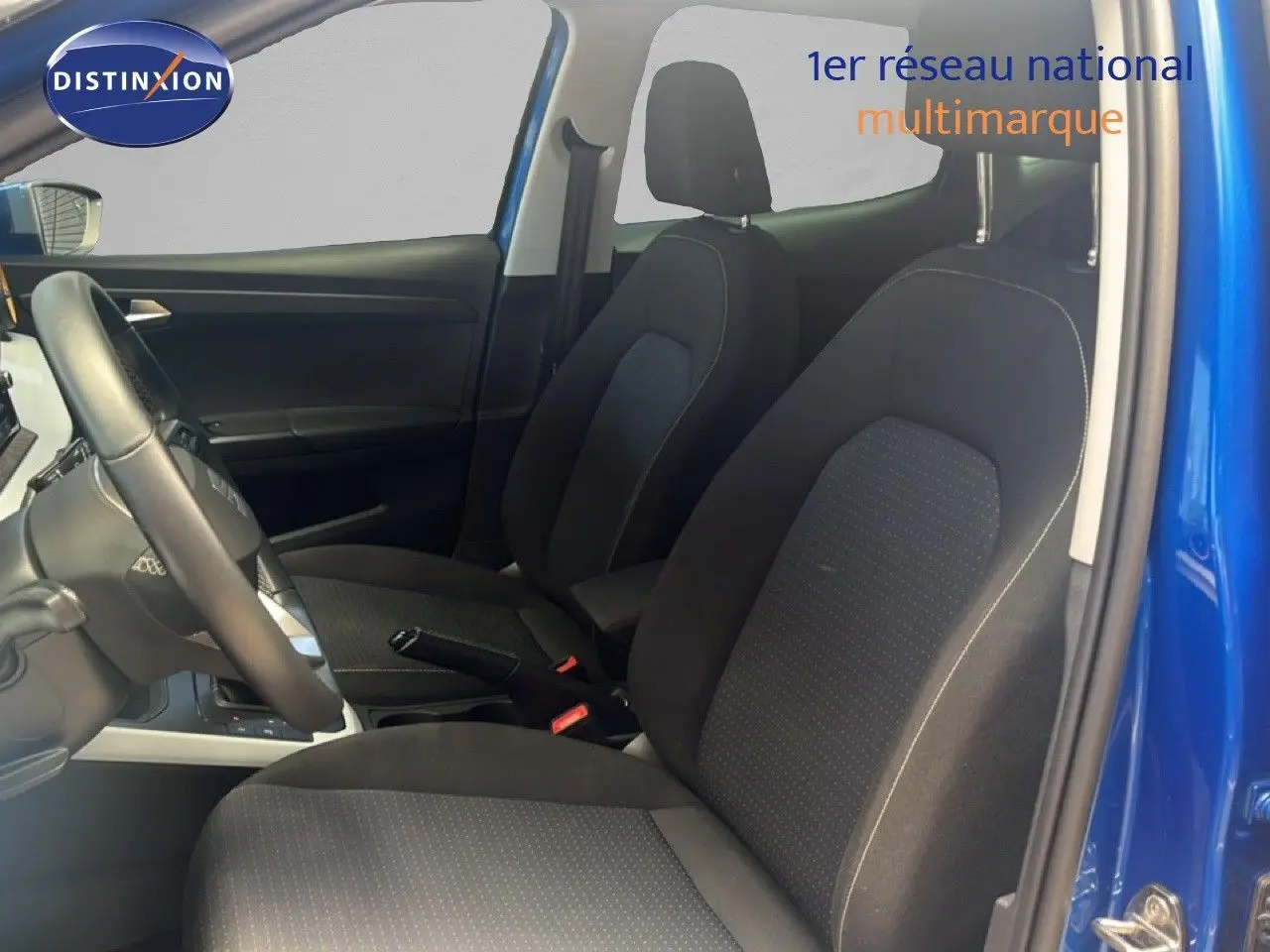 Vue intérieure côté gauche montrant les sièges avant en tissu noir et la portière bleu saphir métal du SEAT Arona 2025.