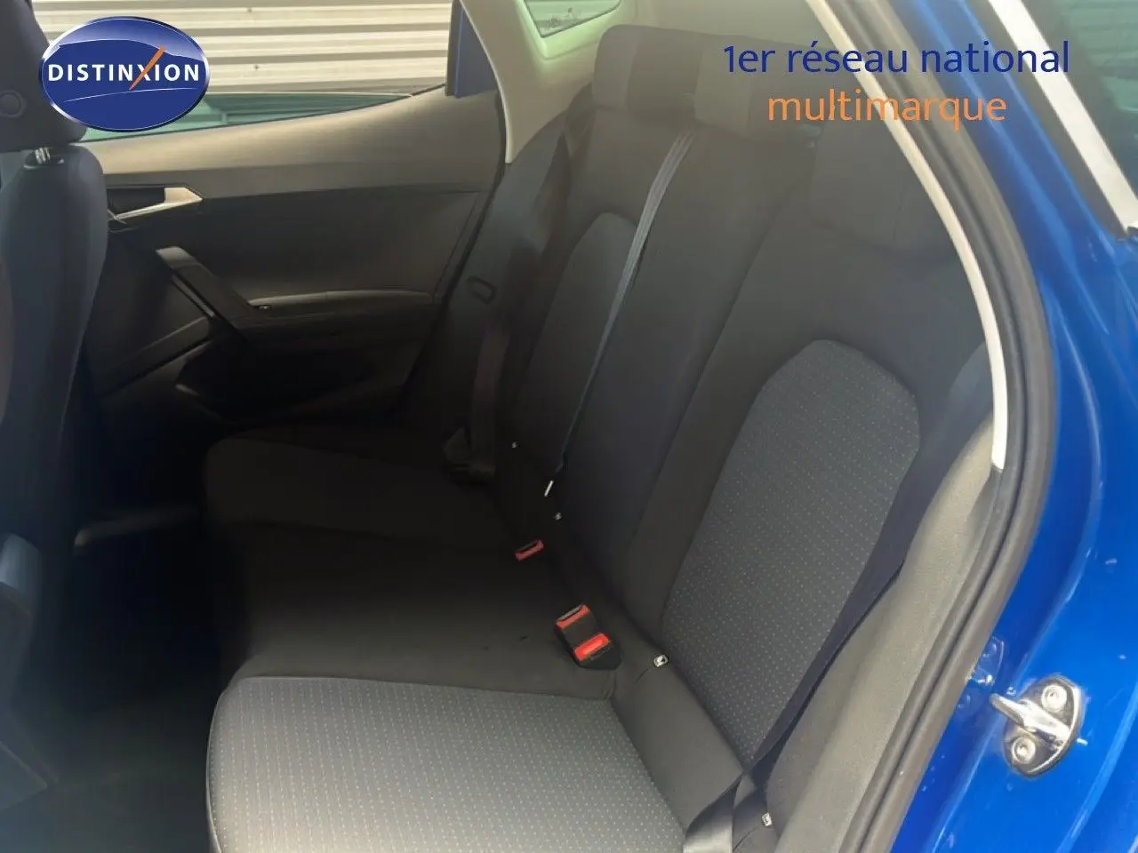 Vue intérieure côté droit des sièges arrière en tissu noir du SEAT Arona bleu saphir métallisé avec porte ouverte.