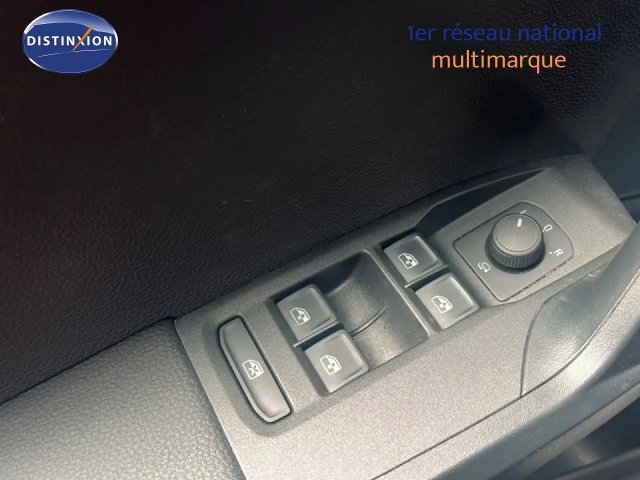 Gros plan sur les commandes des vitres et rétroviseurs côté conducteur d’un SEAT Arona bleu saphir 2025.