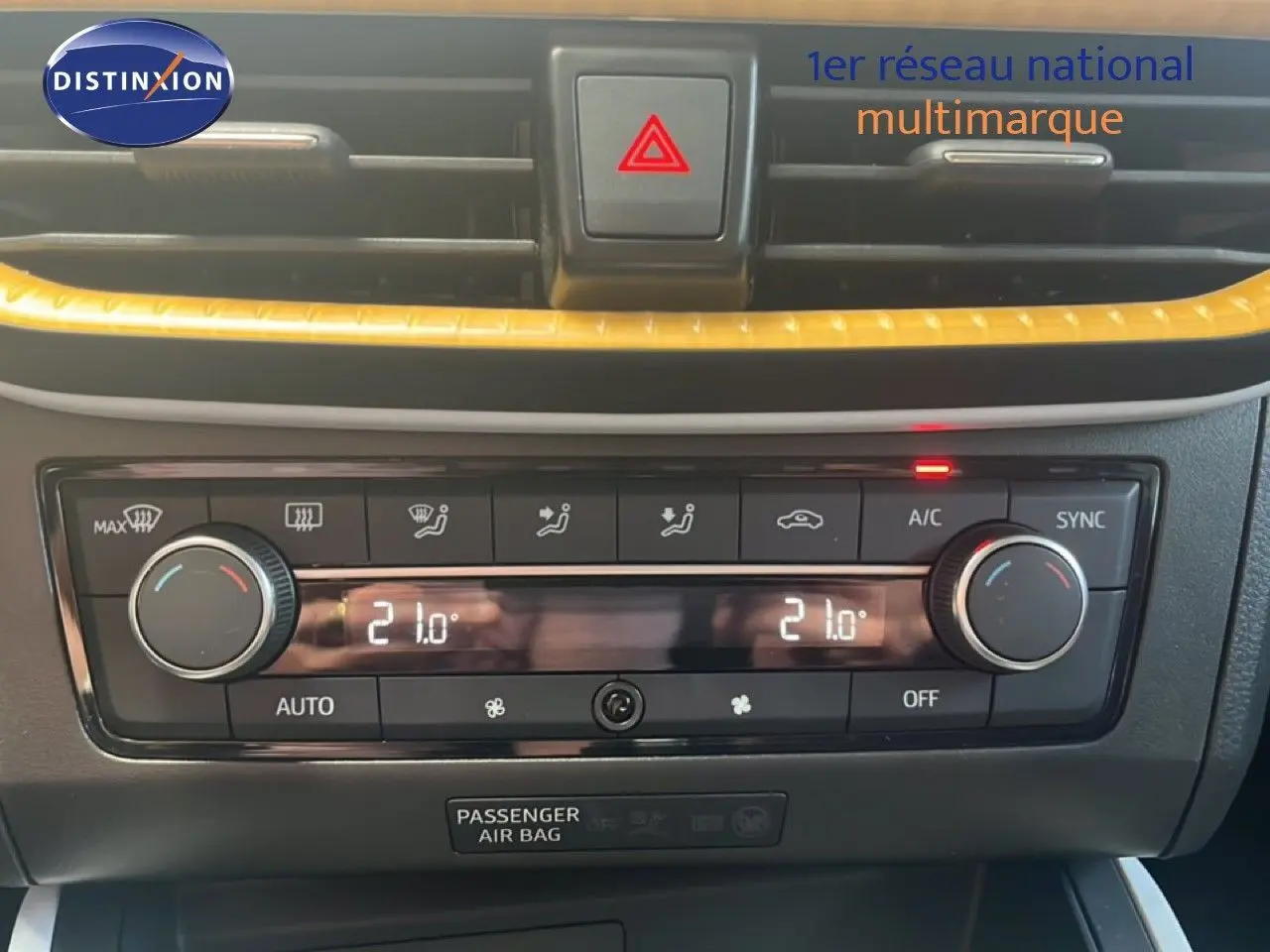 Gros plan sur la console centrale du SEAT Arona 2025, montrant la climatisation automatique avec réglage à 21°C.