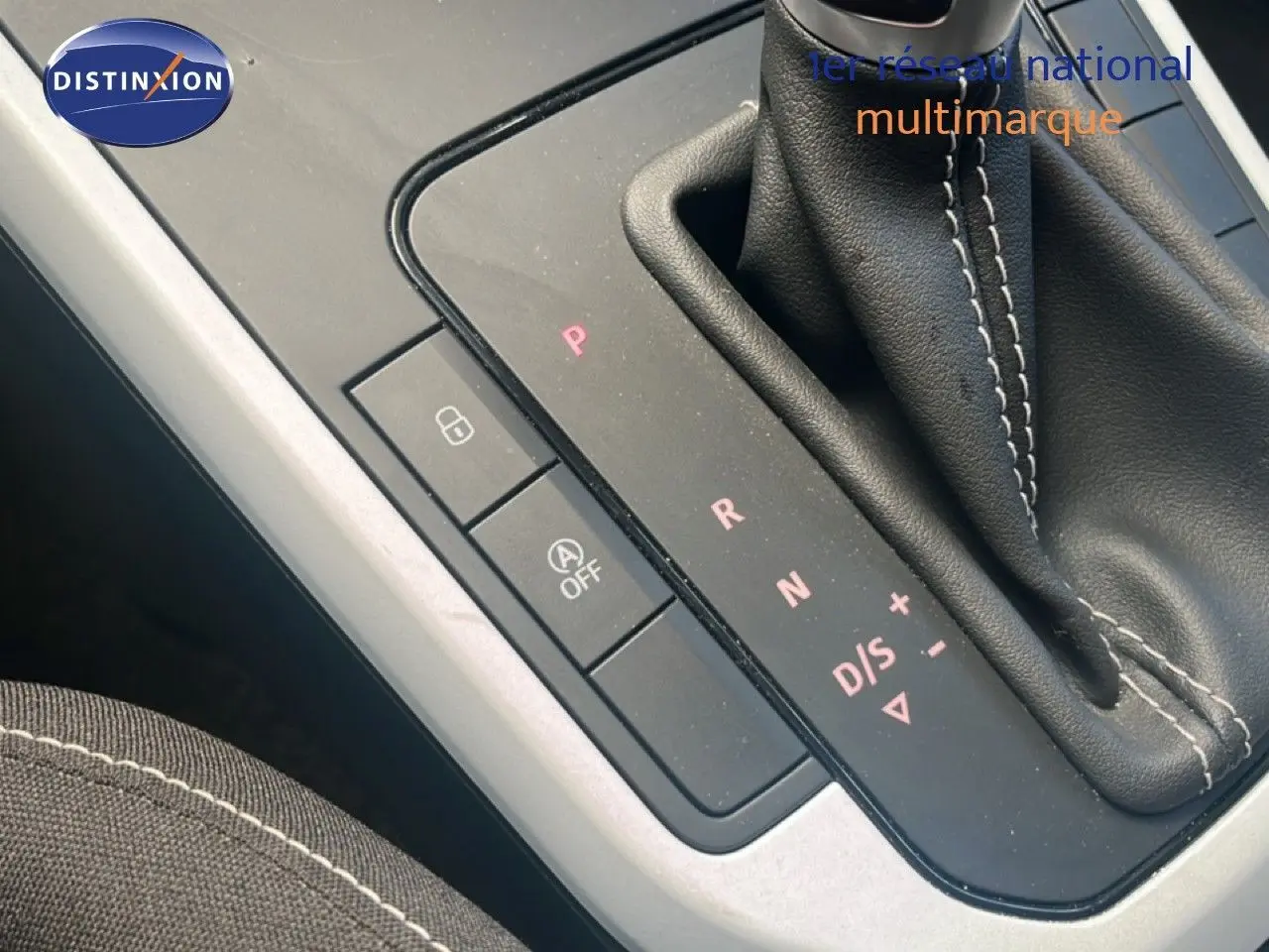 Gros plan sur la console centrale avec levier de vitesses automatique et boutons de commande, intérieur tissu noir.
