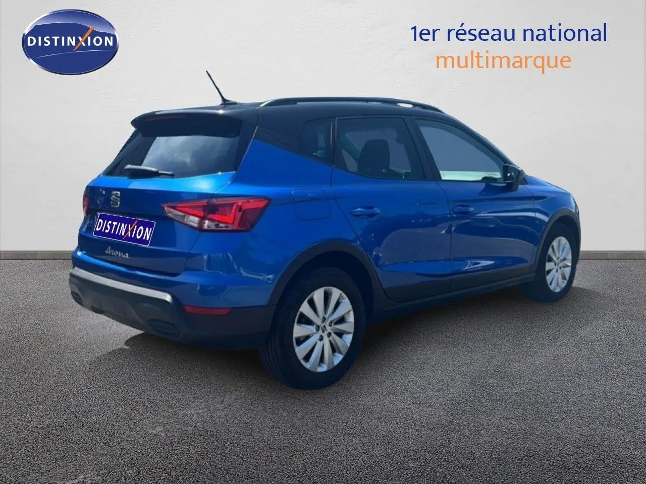 Vue 3/4 arrière droite d'un SEAT Arona bleu saphir métallisé avec toit noir, sur fond neutre extérieur.