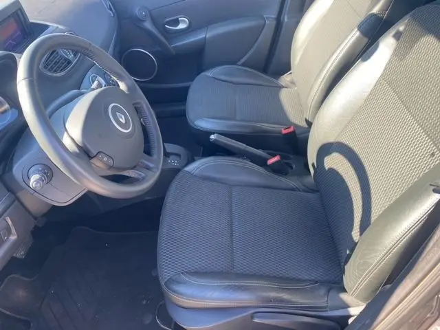 Intérieur de Renault Clio III 110 ch exception tomtom 2010, vue côté conducteur montrant sièges noirs et tableau de bord.