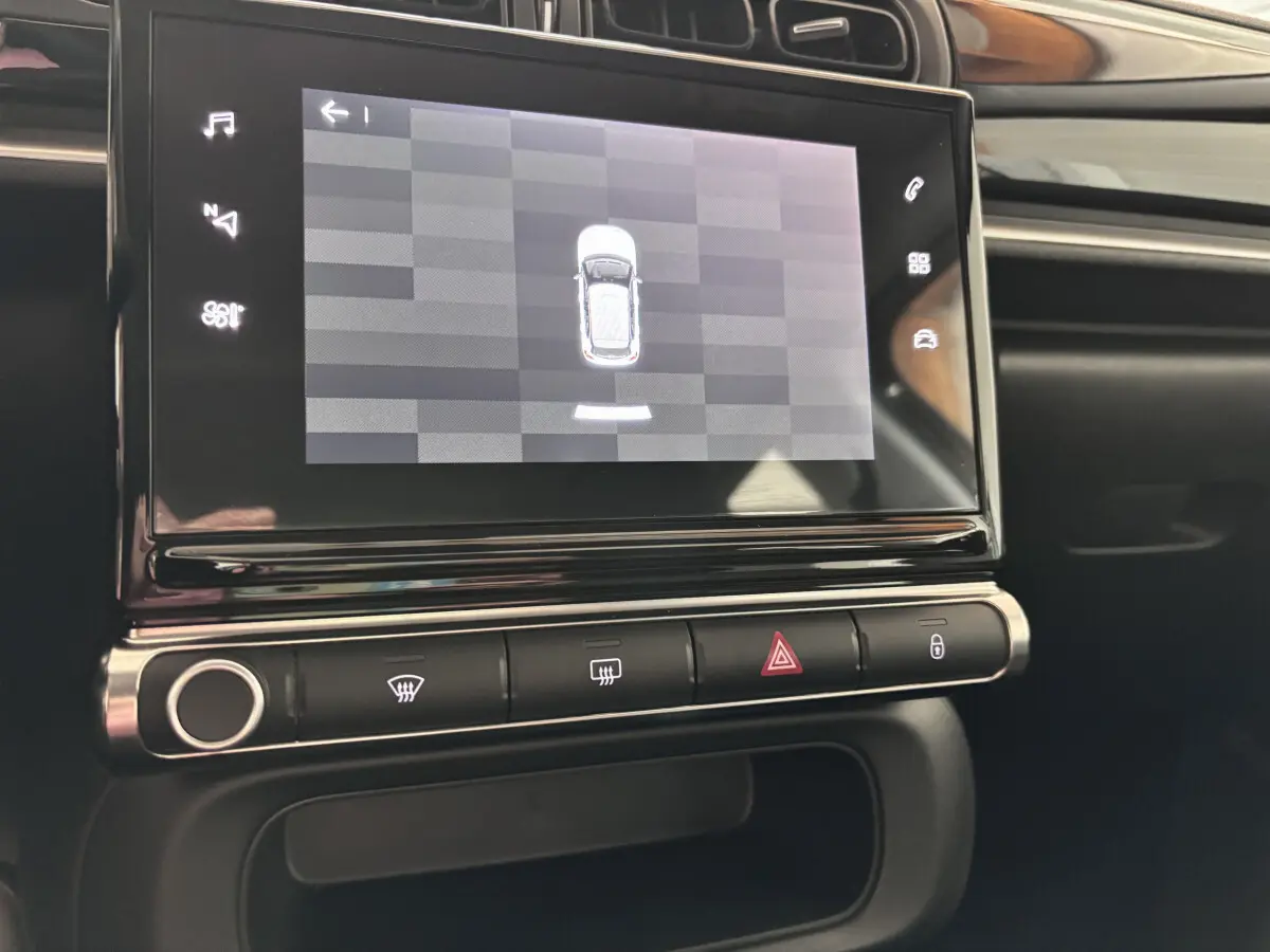 Écran tactile central affichant la vue aérienne du véhicule dans l'habitacle noir de la Citroën C3 PureTech 2024.