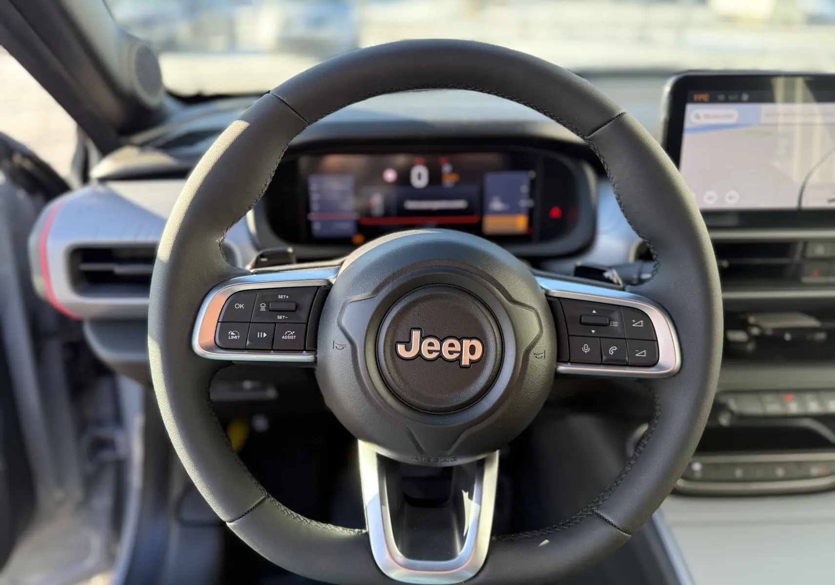 Vue centrée sur le volant noir du Jeep Avenger 2025, avec tableau de bord numérique et écran tactile visible.