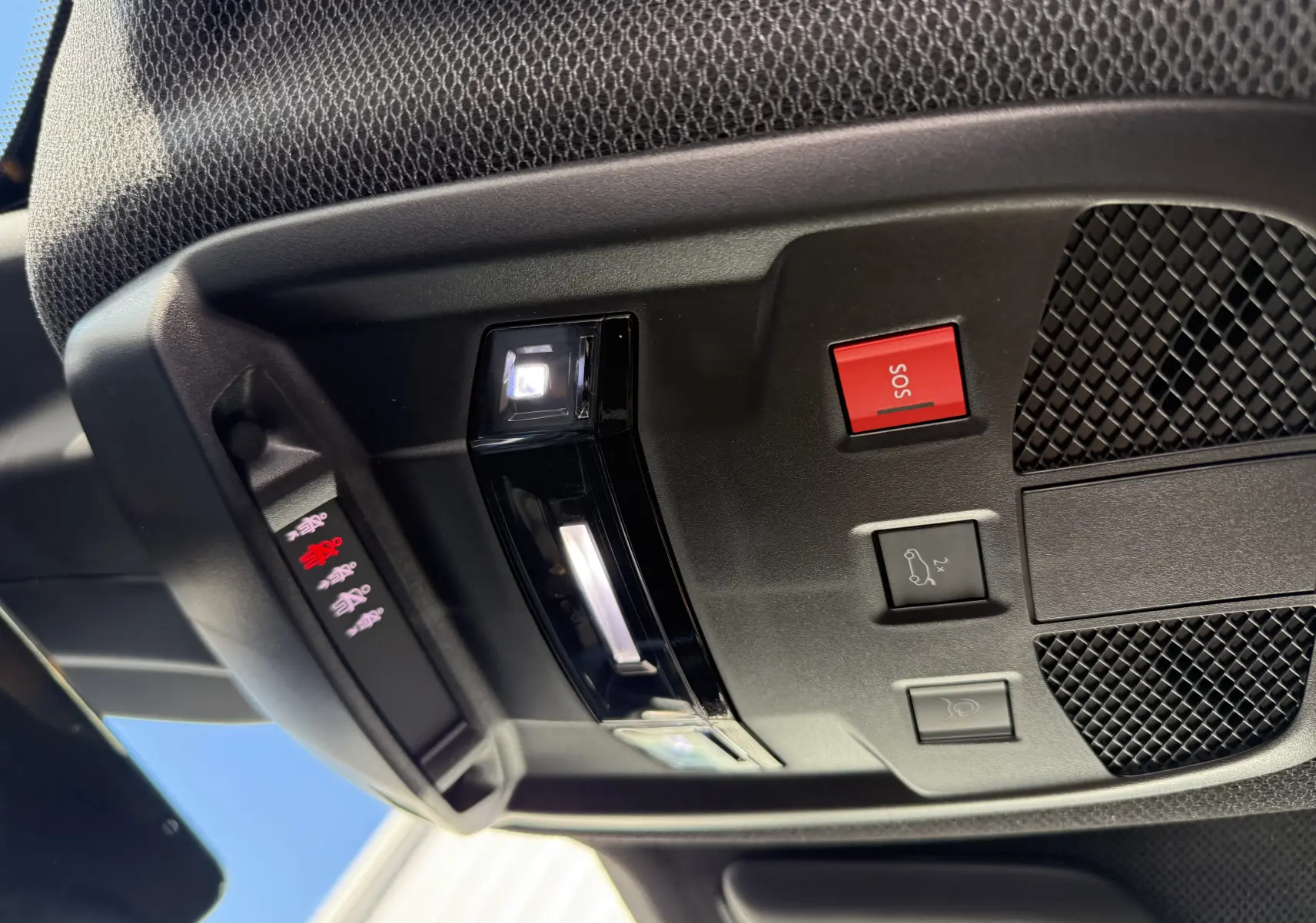 Vue en gros plan du plafonnier intérieur du Jeep Avenger gris Storm, avec boutons SOS et ouverture hayon.