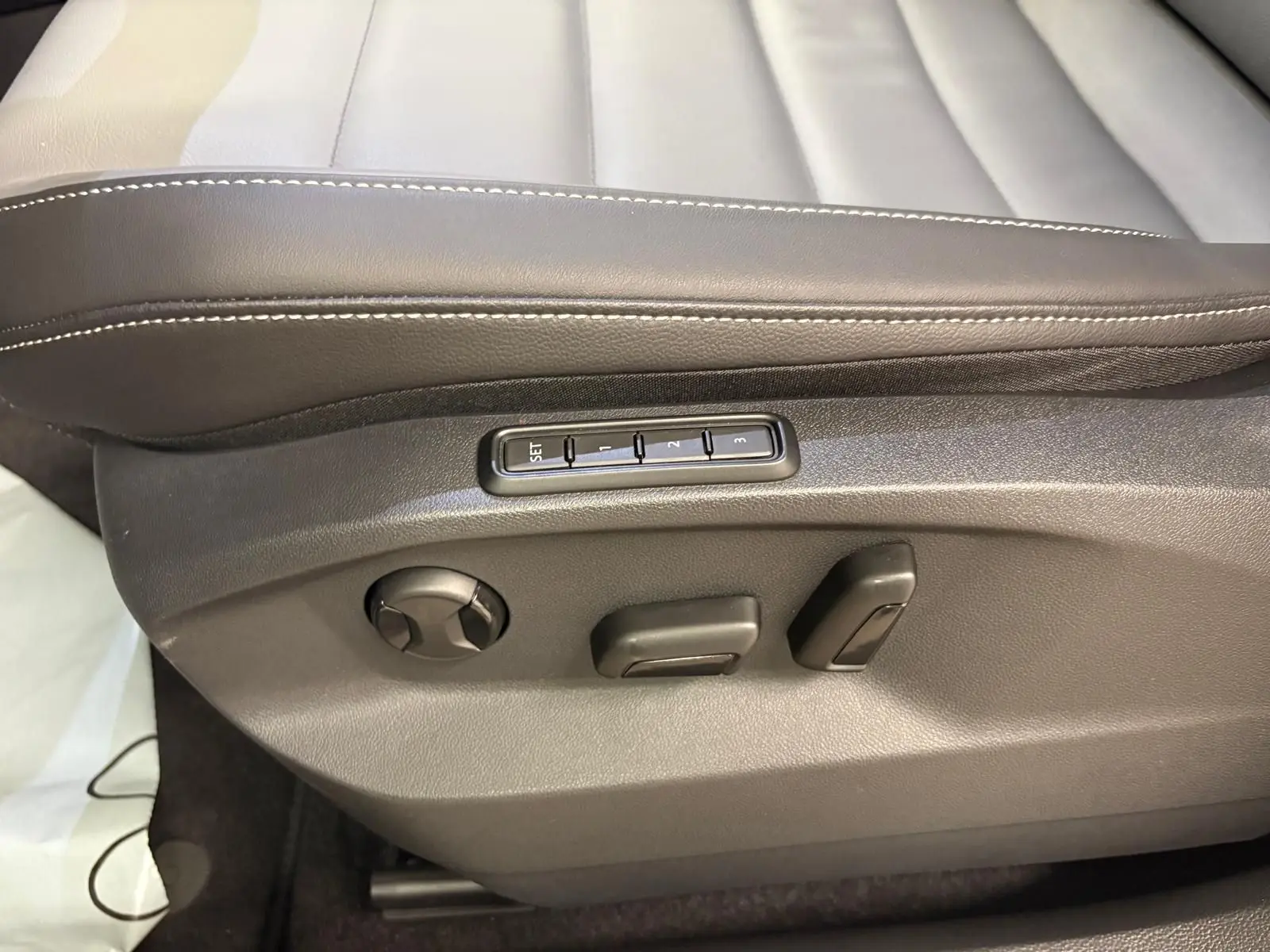 Détail des commandes de réglage électrique du siège conducteur en cuir noir du Volkswagen T-Roc 2025.