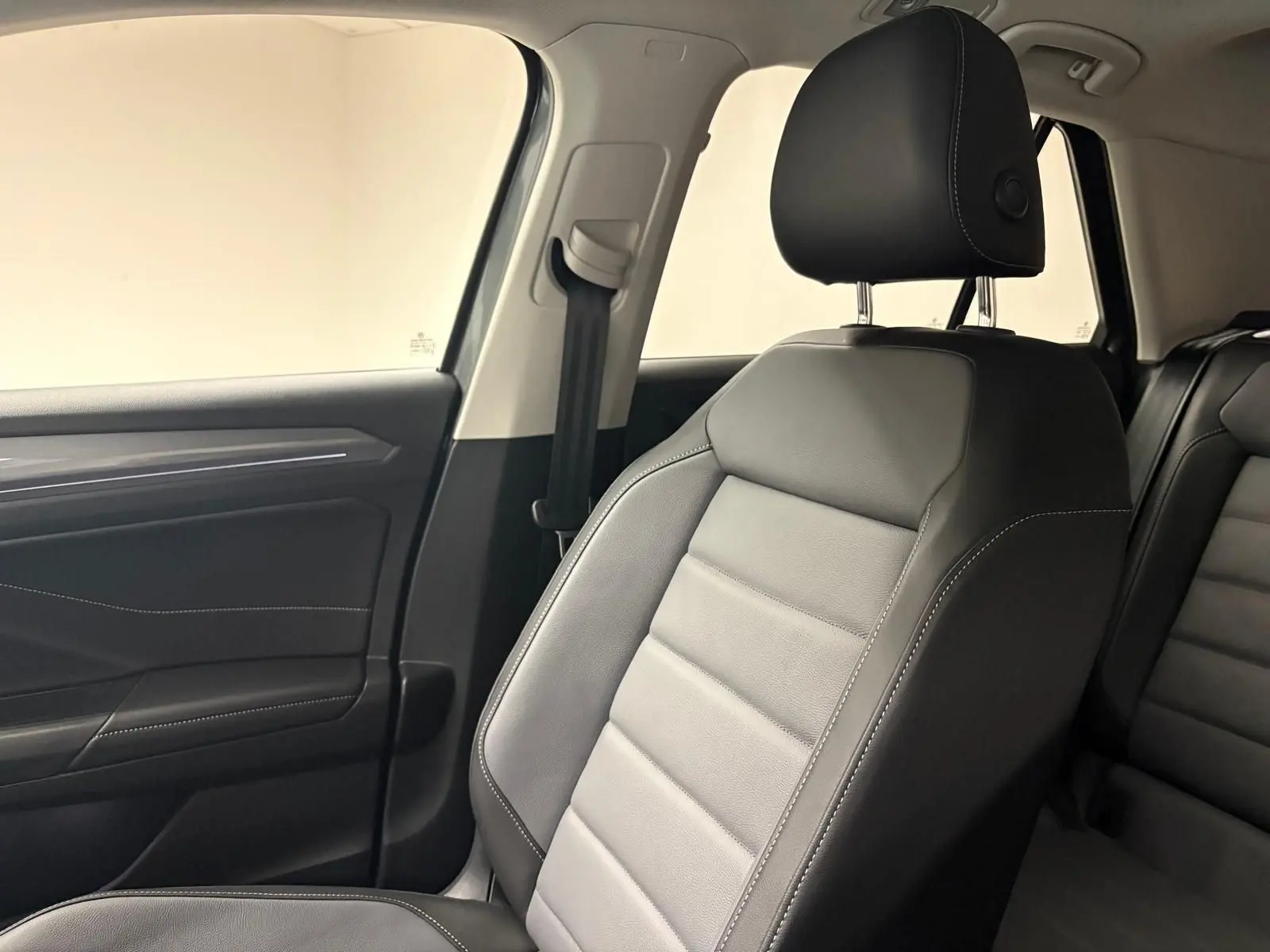 Gros plan sur le siège avant droit en cuir noir avec surpiqûres blanches dans l'habitacle du Volkswagen T-Roc 2025.