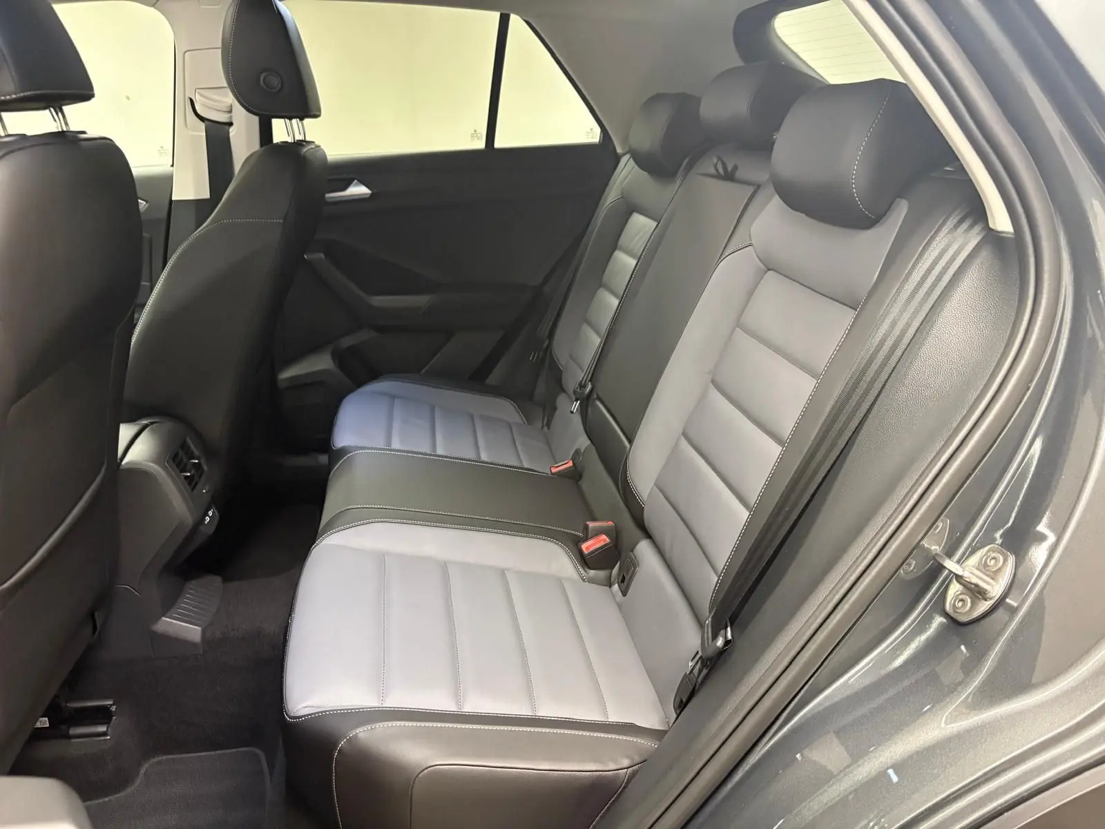 Vue intérieure côté droit des sièges arrière en cuir bi-ton gris clair et noir du Volkswagen T-Roc 2025 Gris Indium.