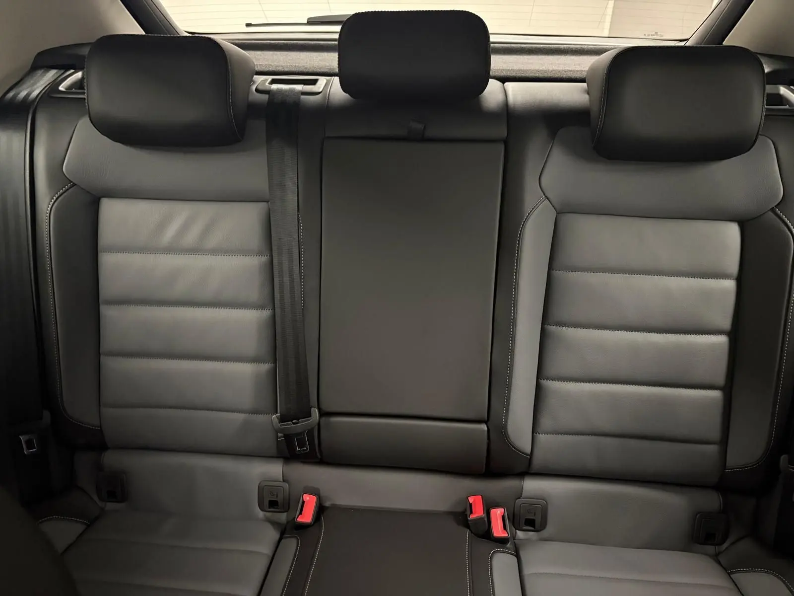 Vue arrière intérieure montrant les sièges arrière en cuir noir du Volkswagen T-Roc 1.5 TSI 2025.