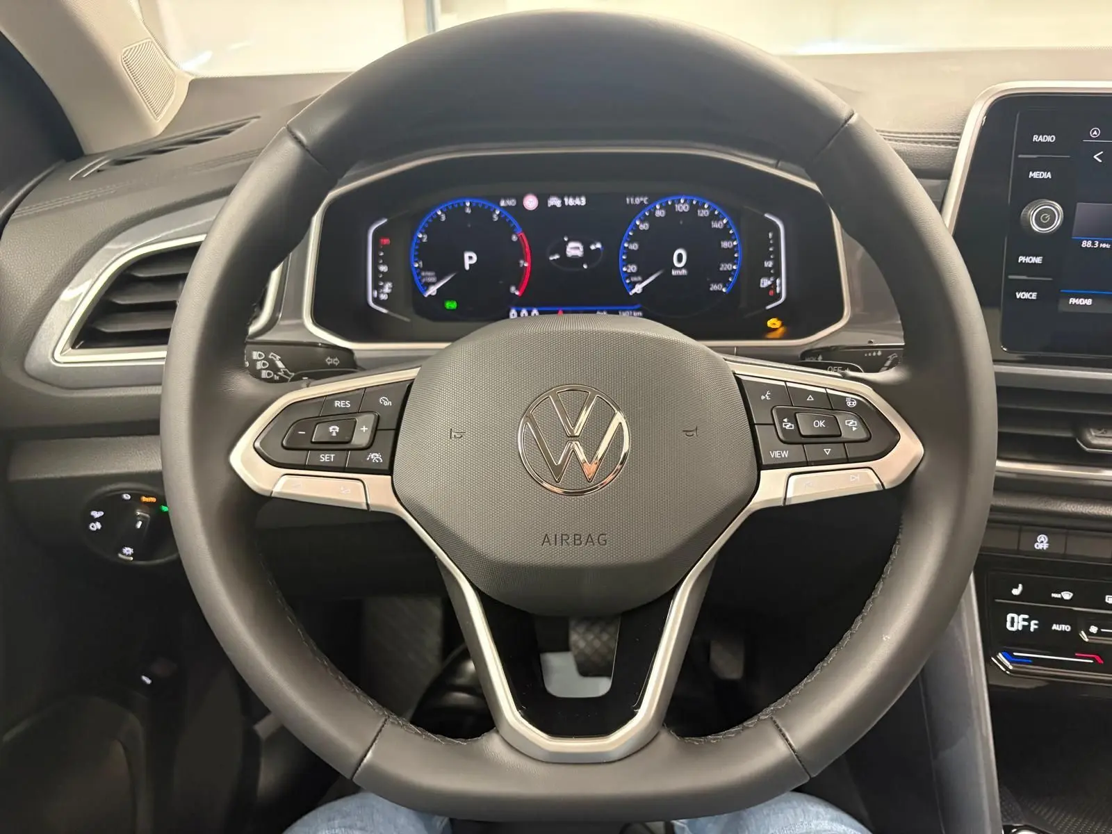 Vue intérieure centrée sur le volant multifonction et le tableau de bord numérique du Volkswagen T-Roc 2025.