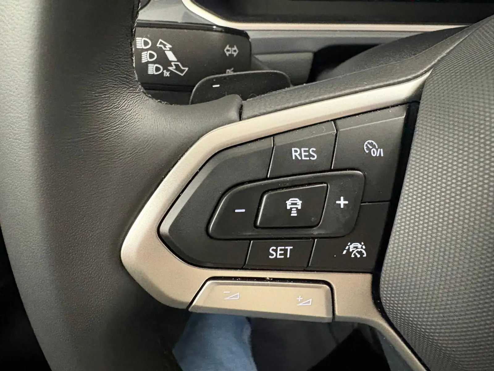 Gros plan sur les commandes de régulateur de vitesse au volant d’un Volkswagen T-Roc 2025, finition Style Exclusive.